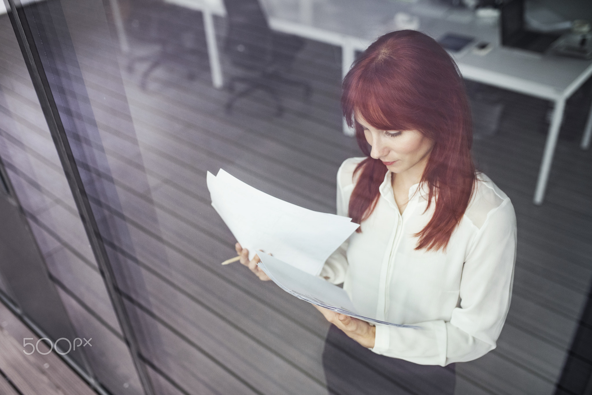 Businesswoman with documents in her office working.