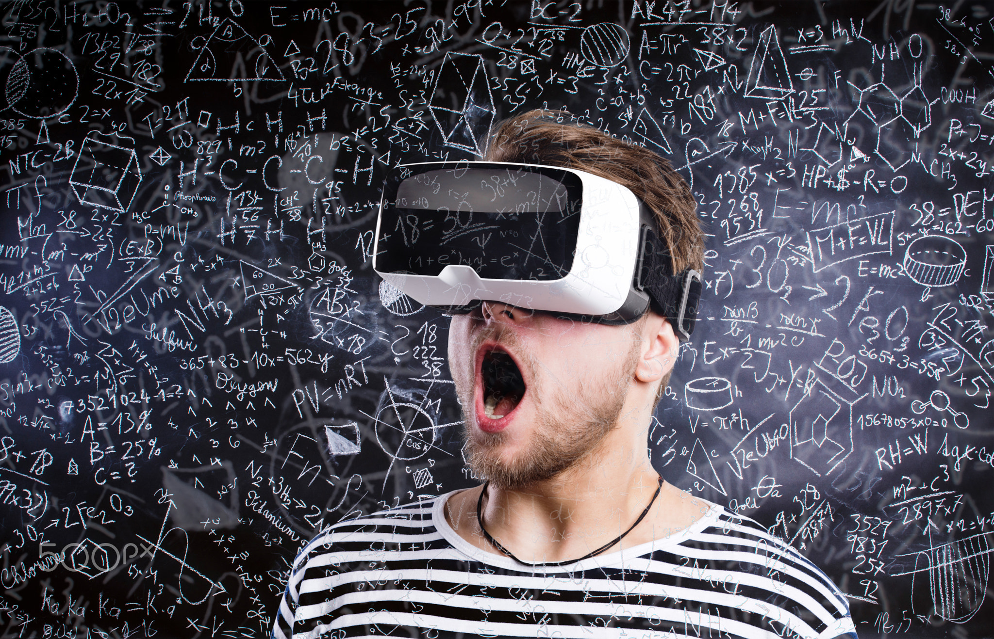 Double exposure. Man wearing virtual reality goggles. Blackboard