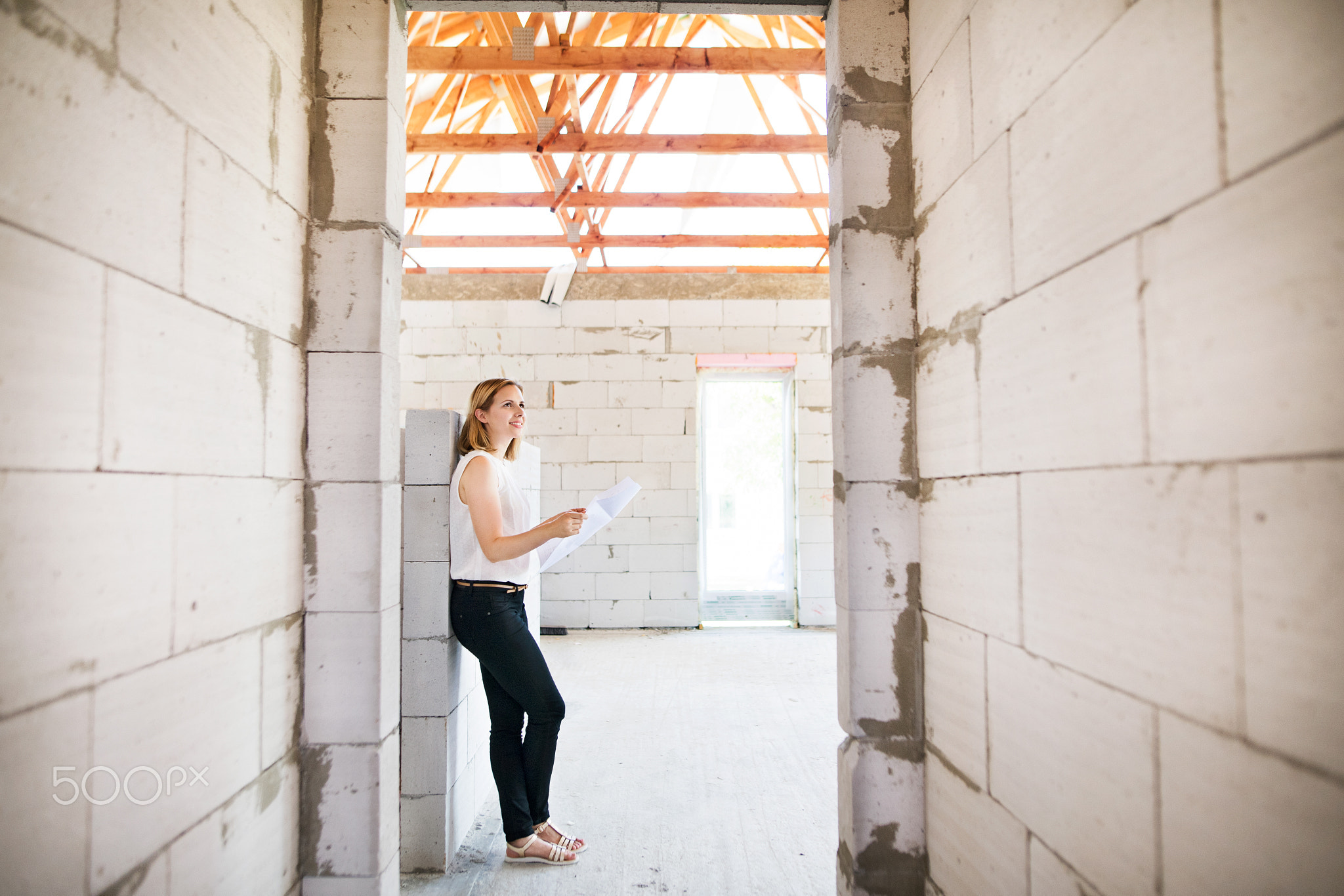 Architect at the construction site looking at blueprints.