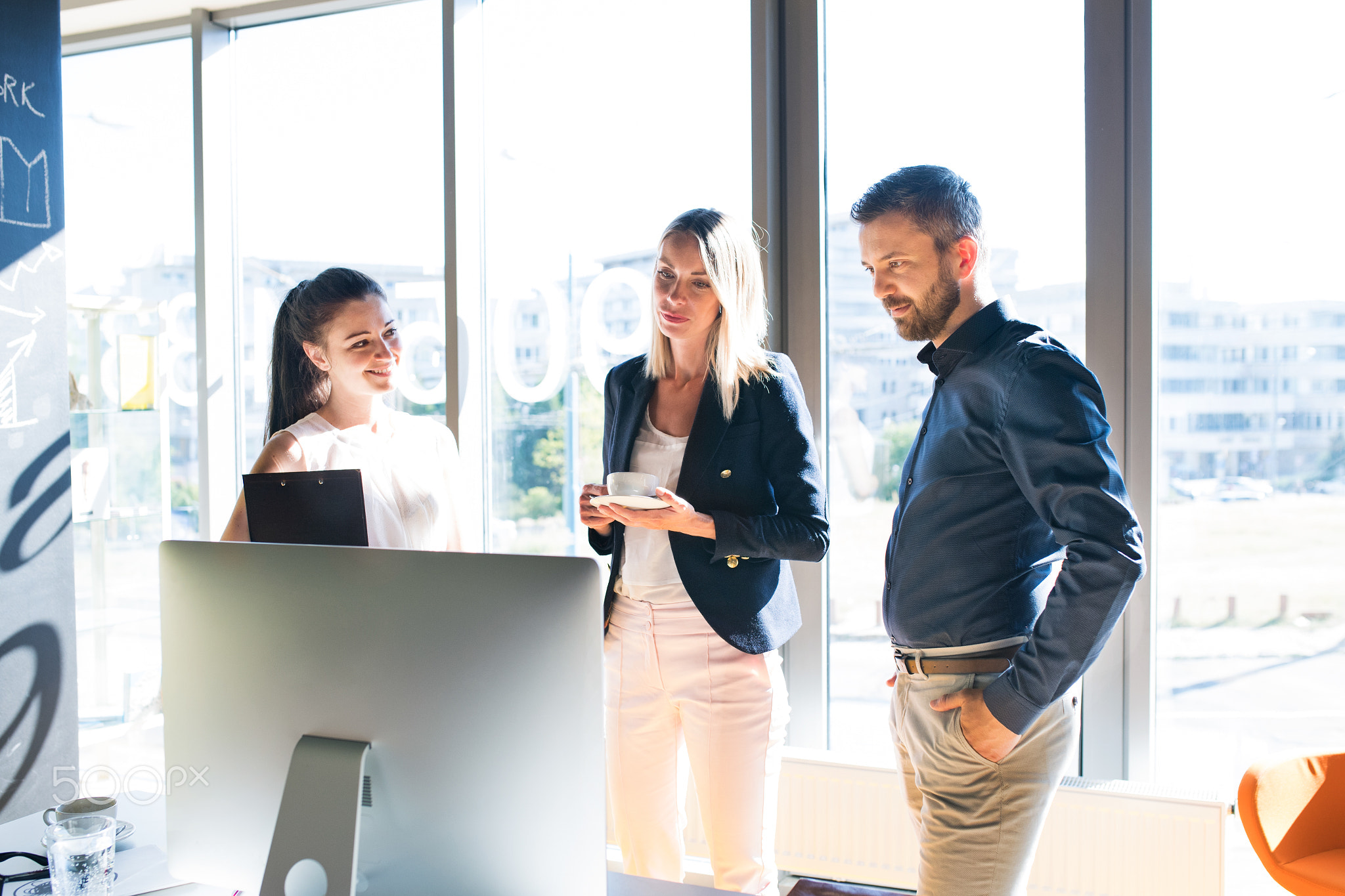 Three business people in the office working together.