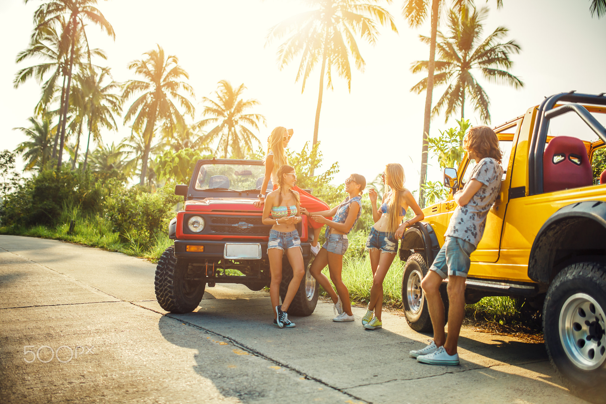 group of friends enjoying vacation on koh samui thailand in jungle with trucks