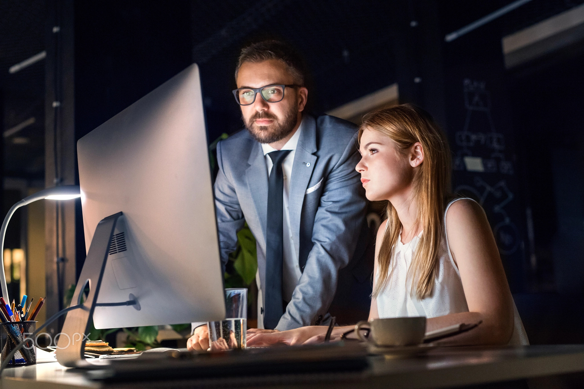 Businesspeople in the office at night working late.