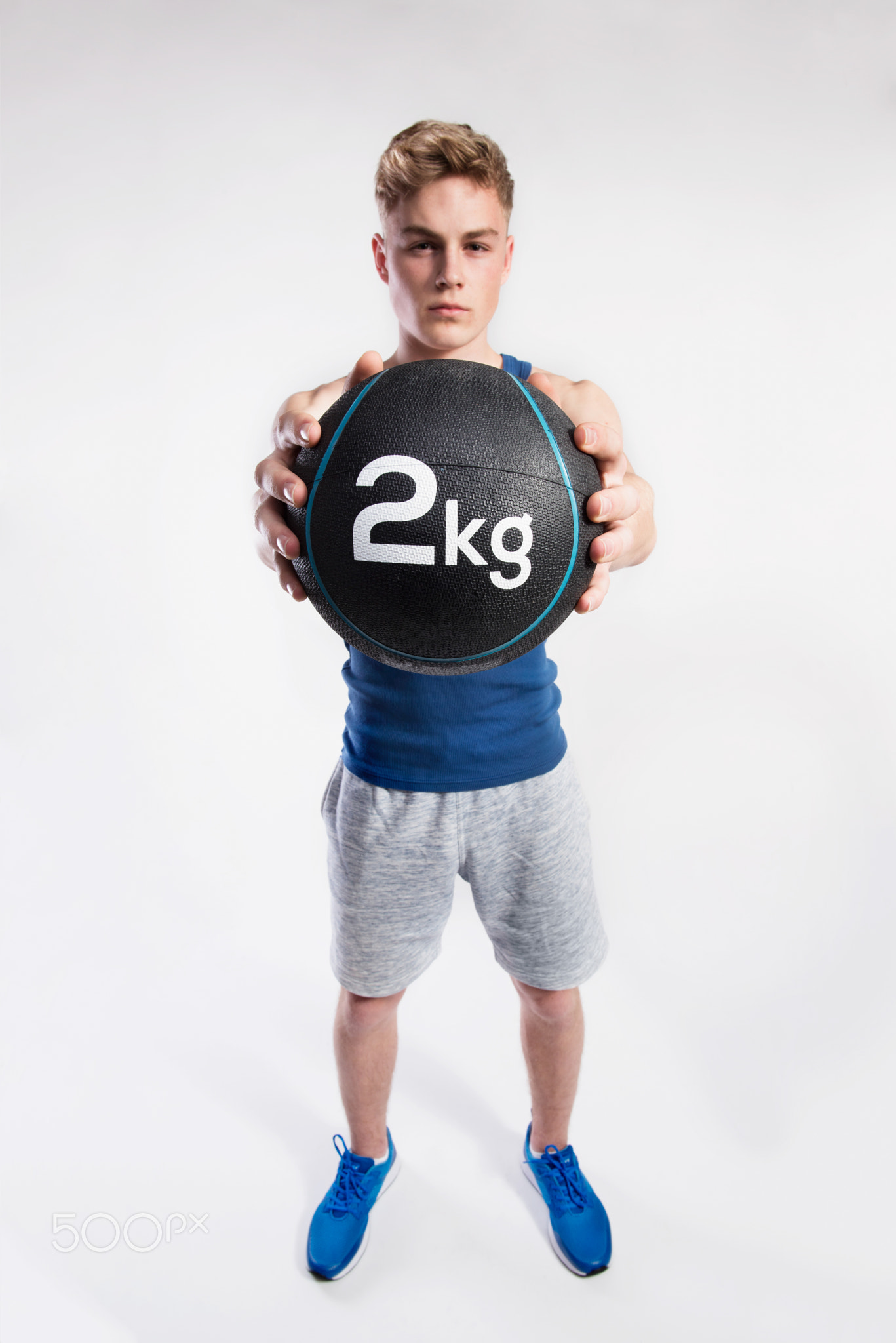 Handsome fitness man holding medicine ball, studio shot.