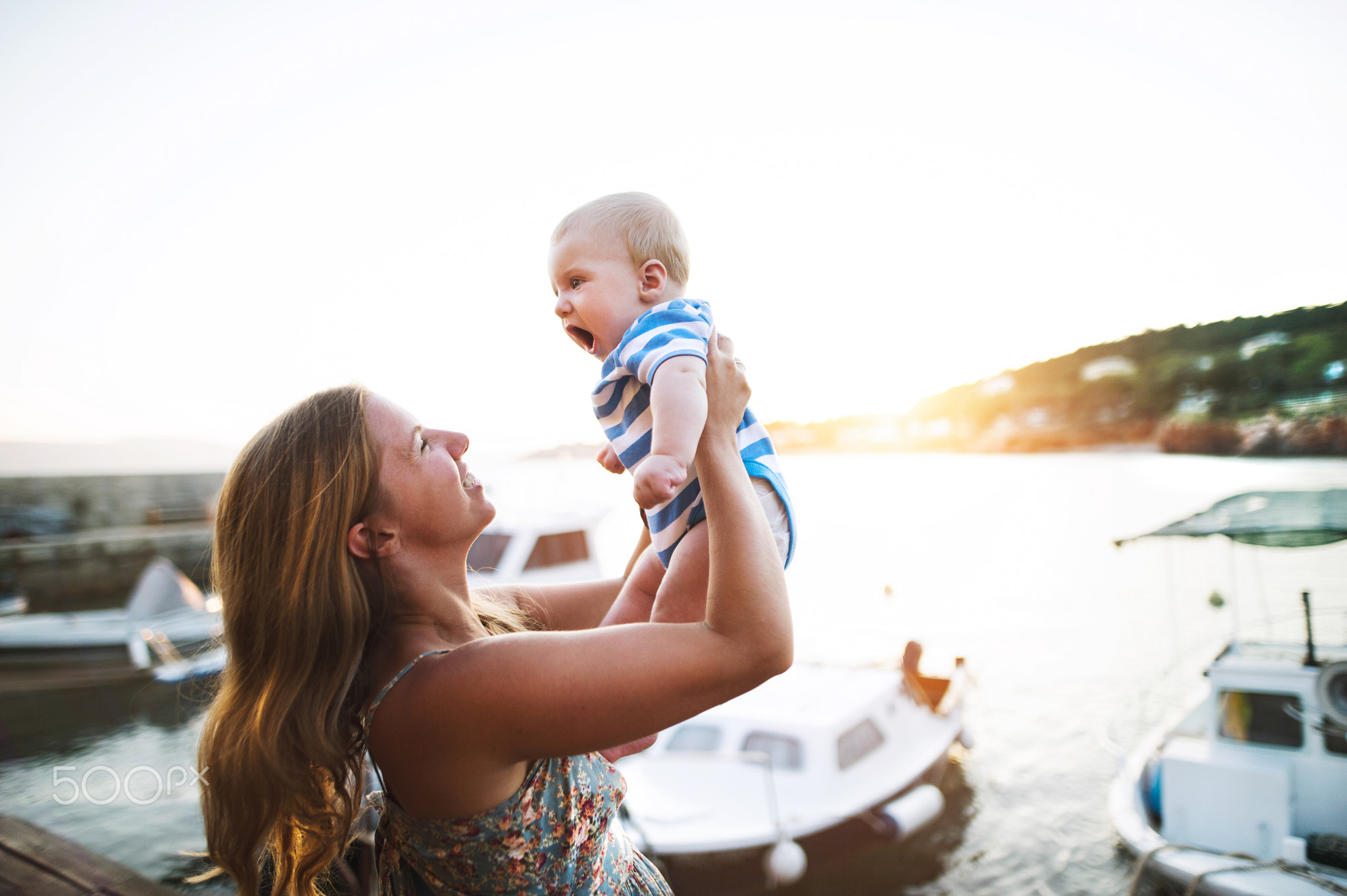 Pretty woman with baby son enjoying their time at seaside.