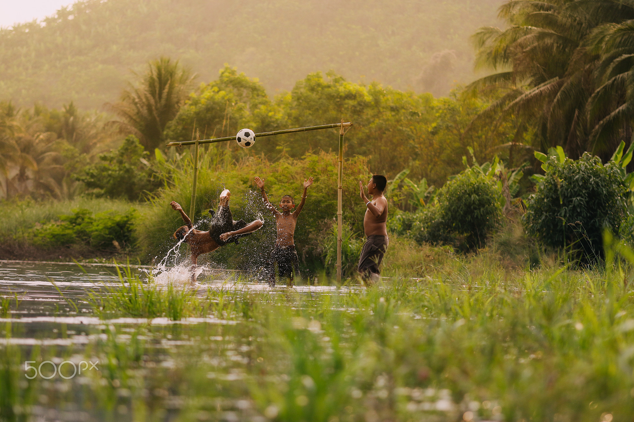 Children playing football in the river,