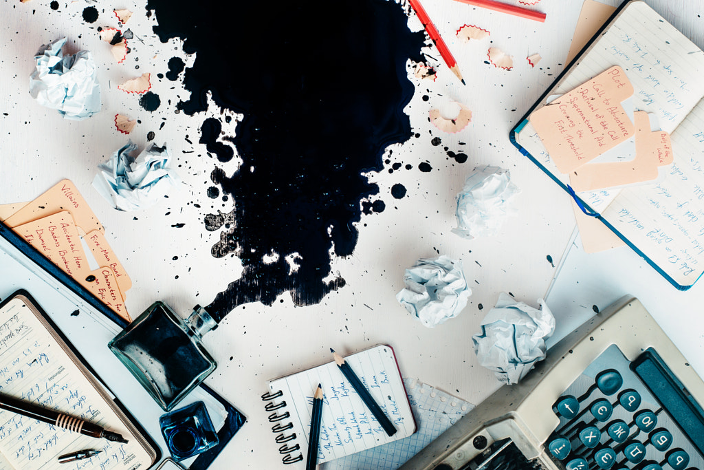 Writer workplace with spilled ink, stationery and a typewriter. Crumpled paper balls with pencils... by Dina (Food Photography) on 500px.com