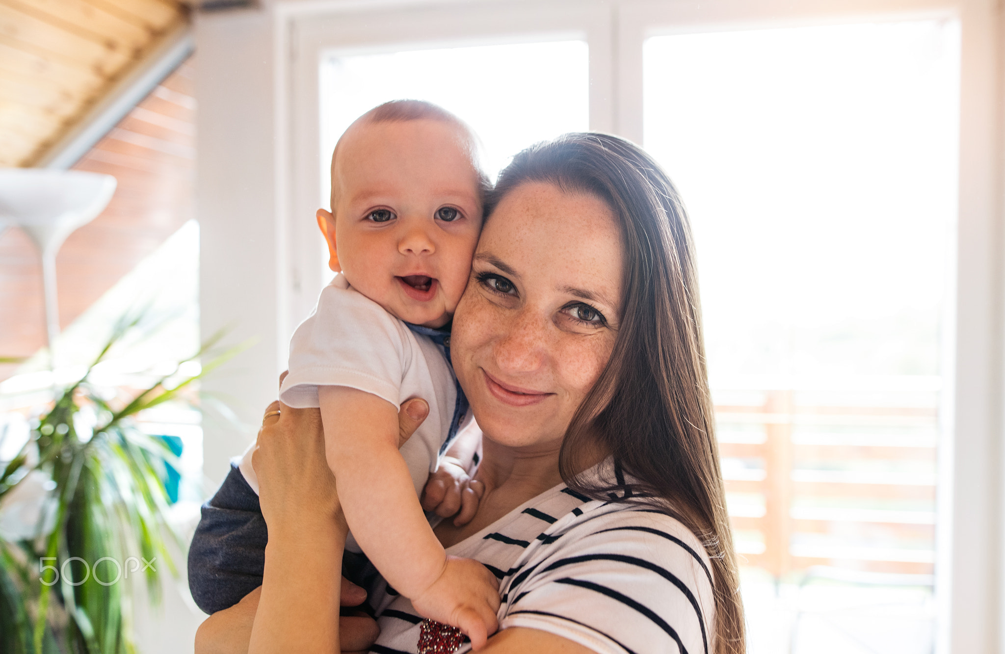 Beautiful mother holding her cute baby son