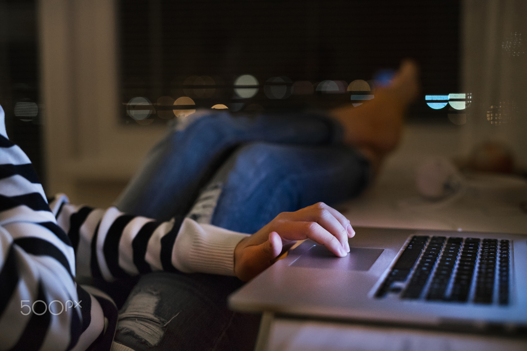 Unrecognizable woman sitting at desk working on laptop.