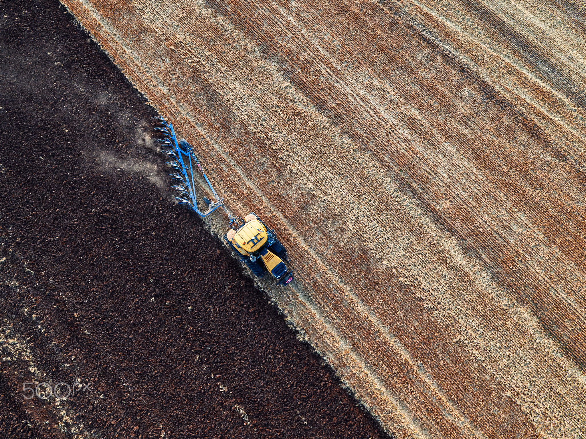 Tractor cultivating field at autumn