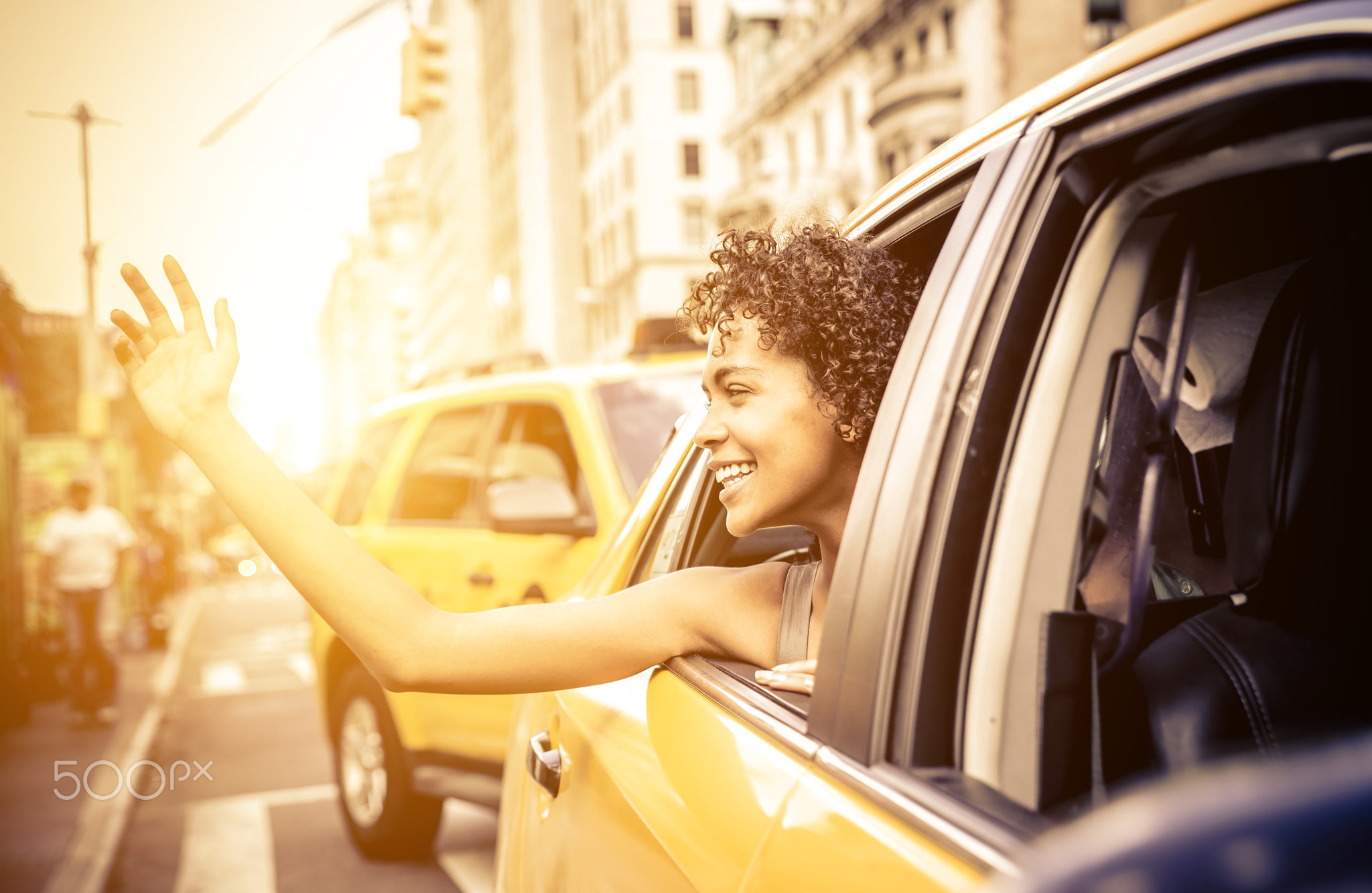 Happy afro american woman on a yellow cab