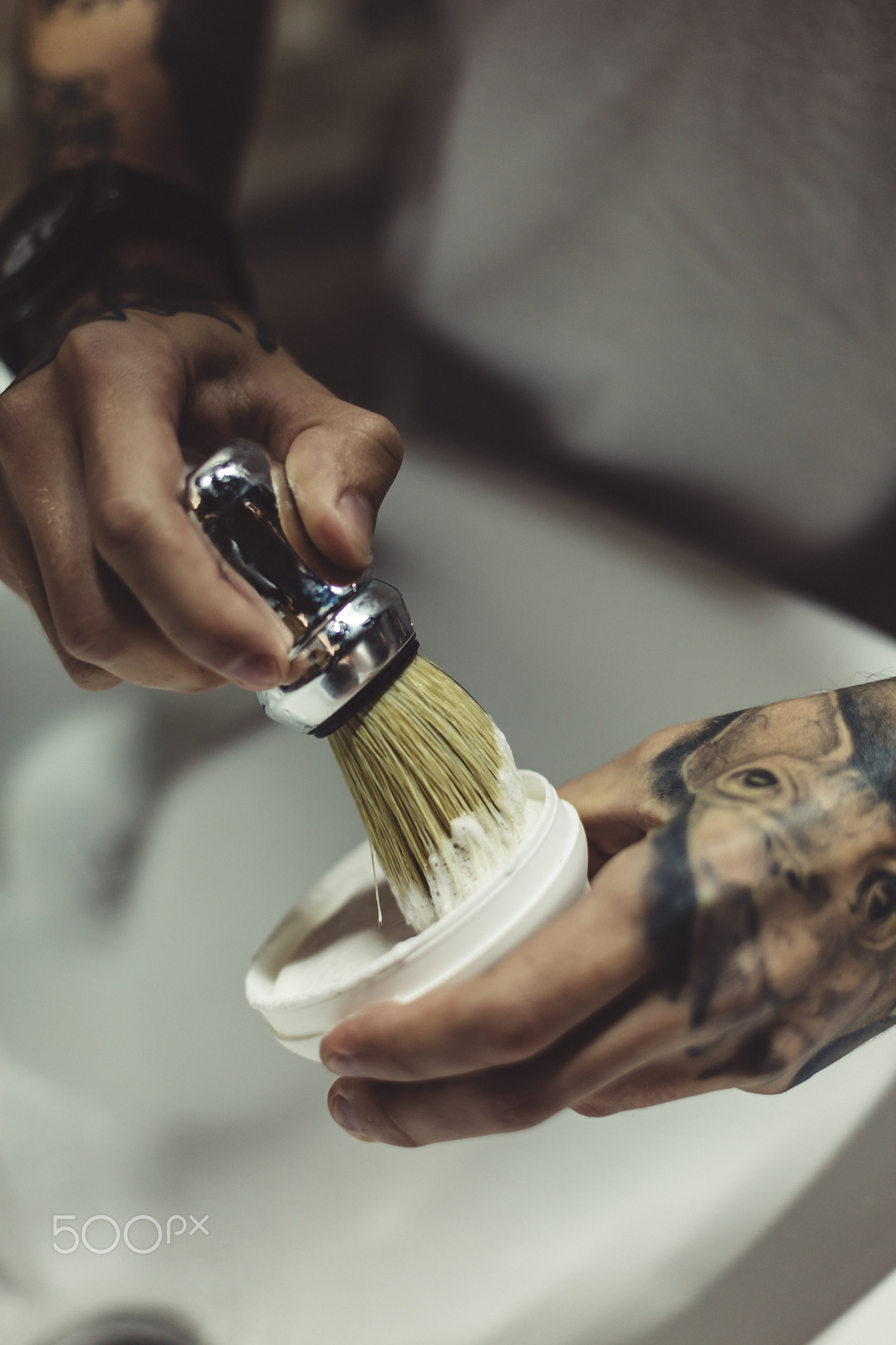 Crop tattooed barber making foam