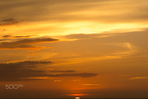 Sunset over the sea through the clouds by Volodymyr Ye