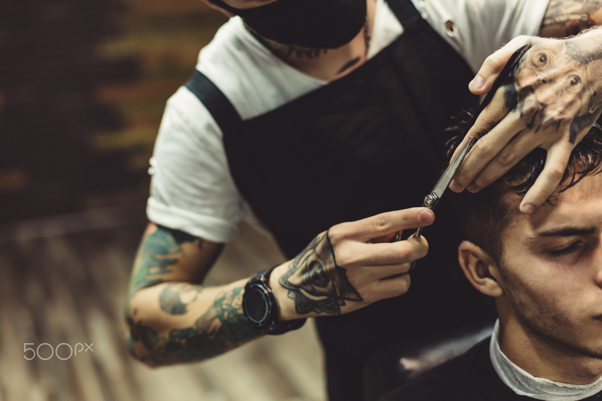 Crop barber doing haircut for client