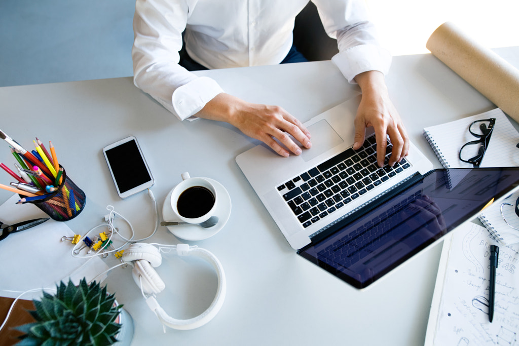 Businesswoman at the desk with laptop in her office. by Jozef Polc on 500px.com