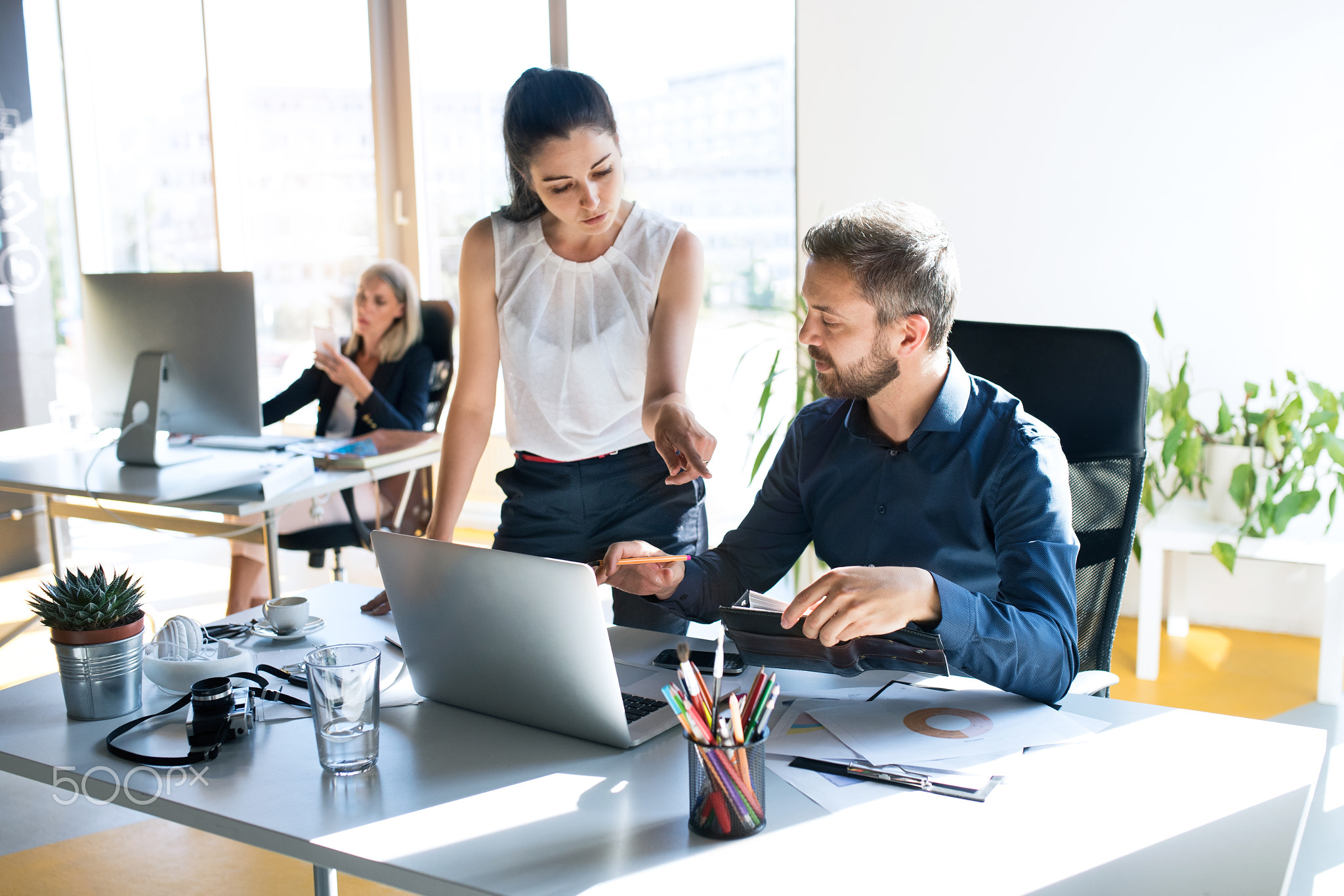 Three business people in the office working together.