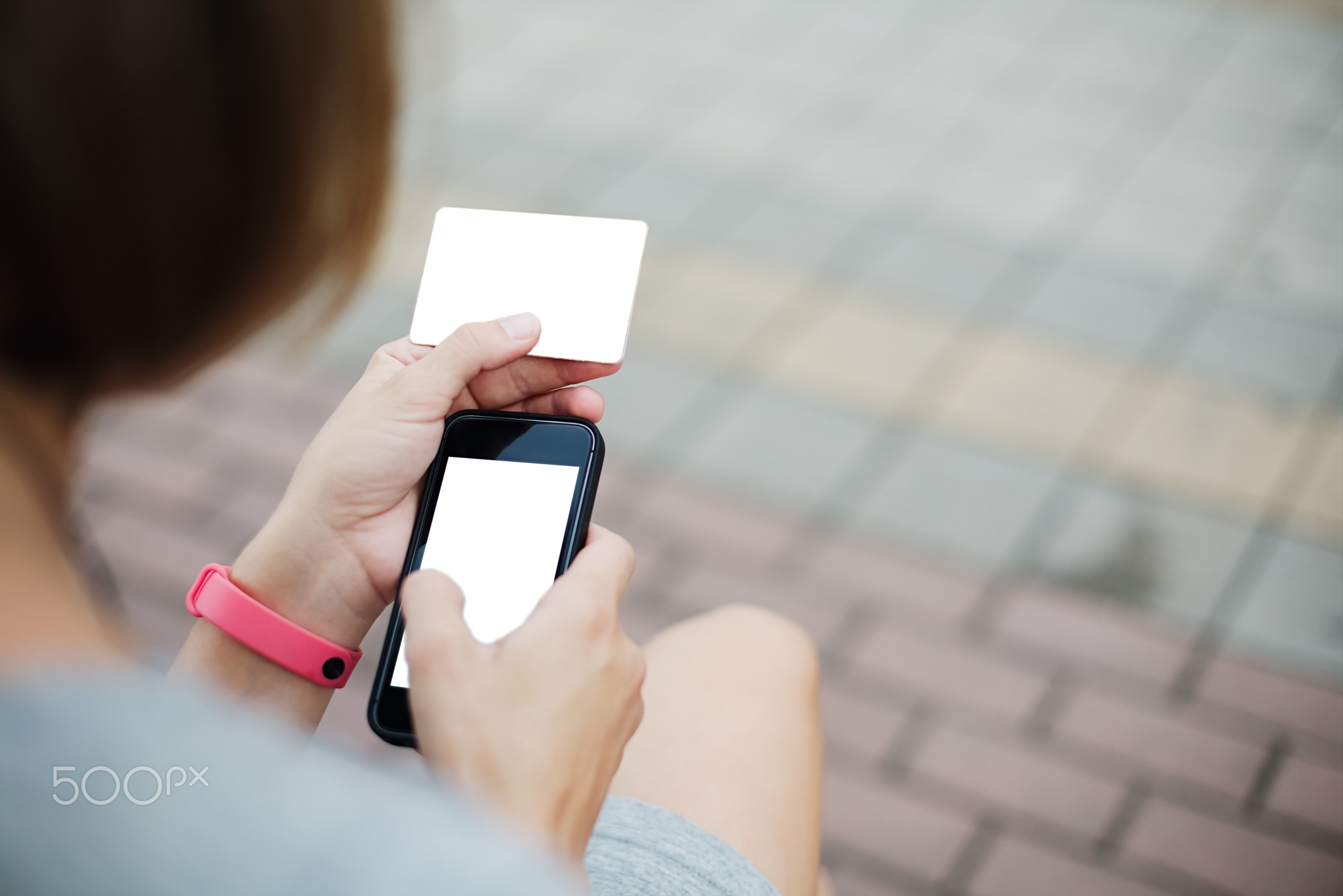 Woman using phone and card for shopping