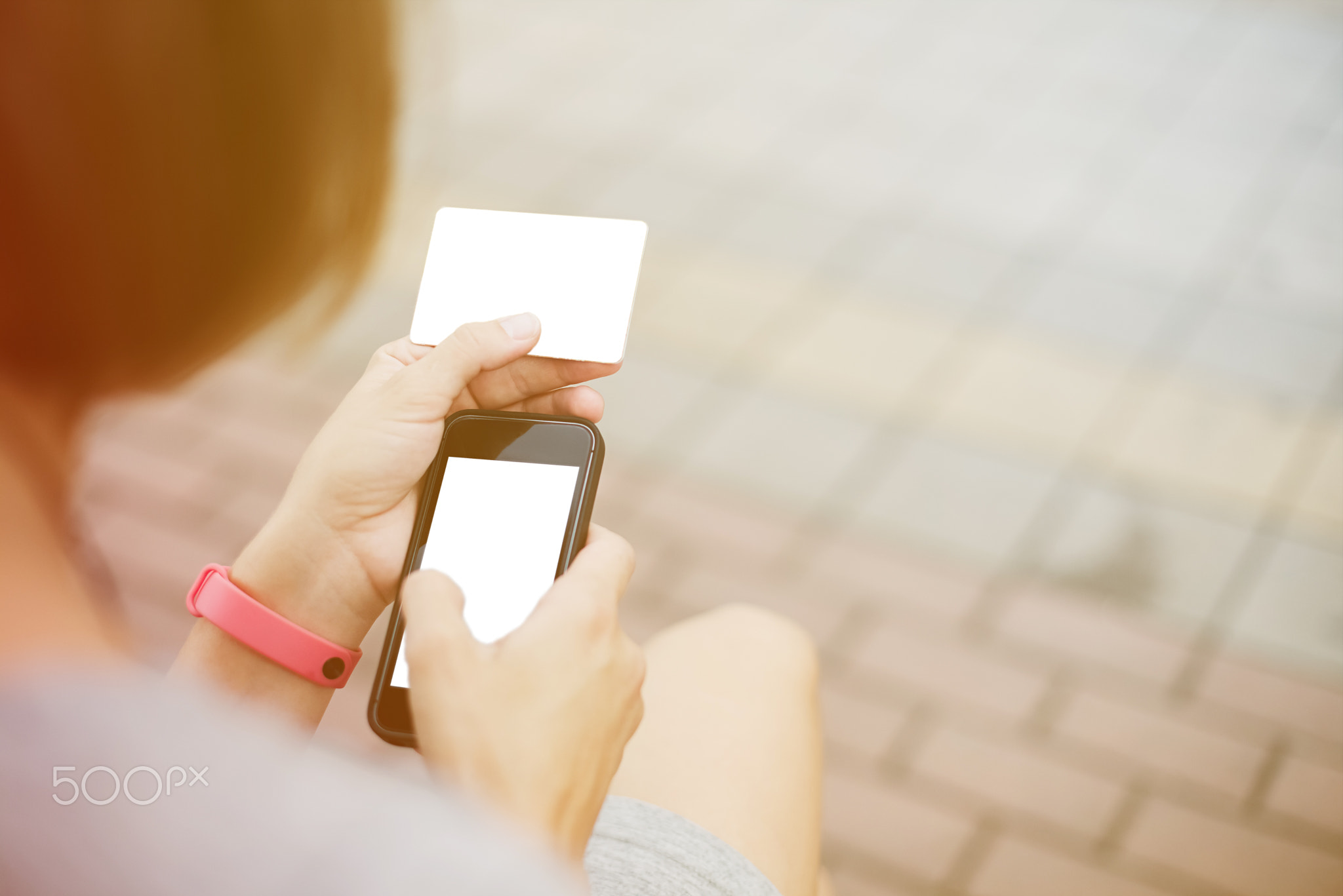 Woman using phone and card for shopping
