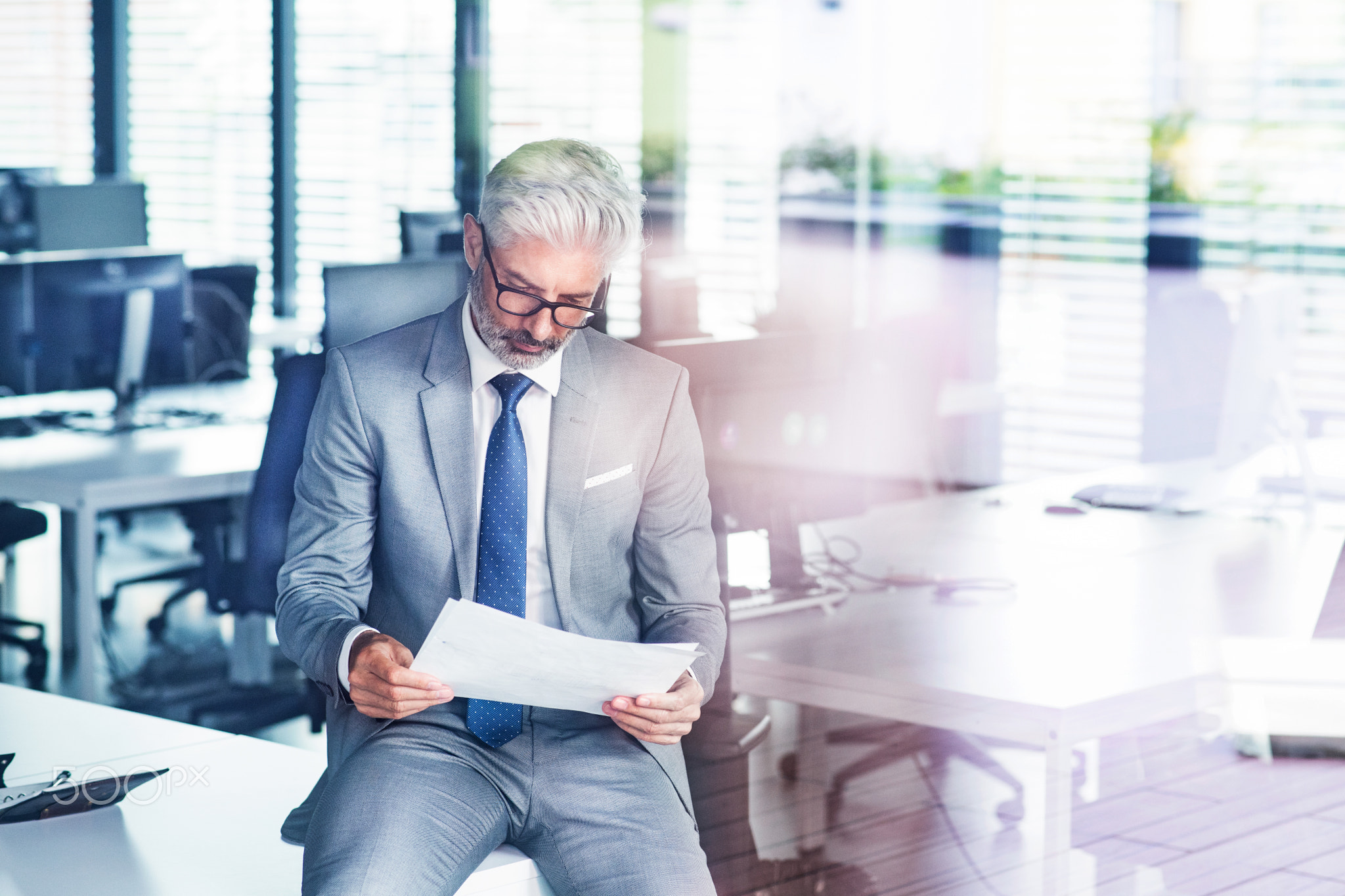 Mature businessman in gray suit in the office.