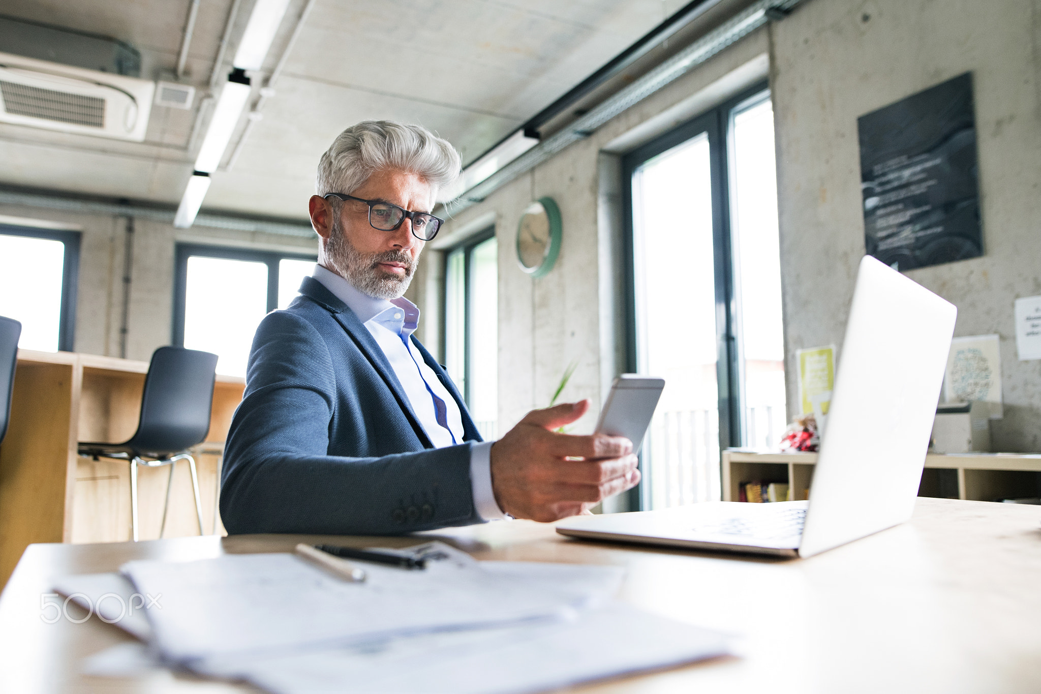 Mature businessman with laptop and smart phone.