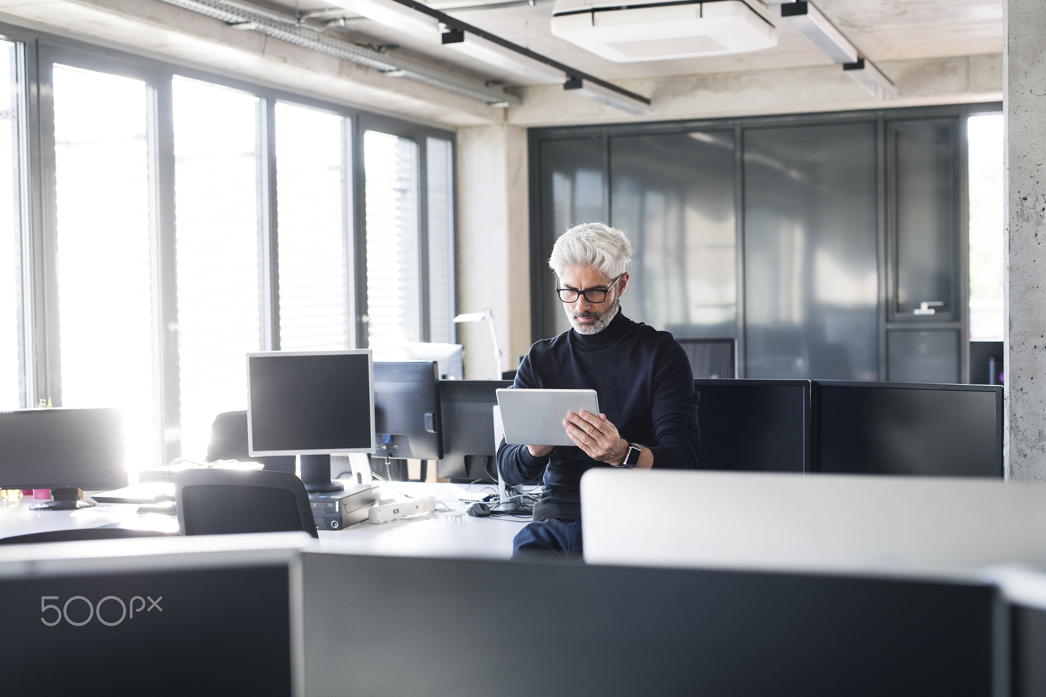 Mature businessman with tablet in the office.