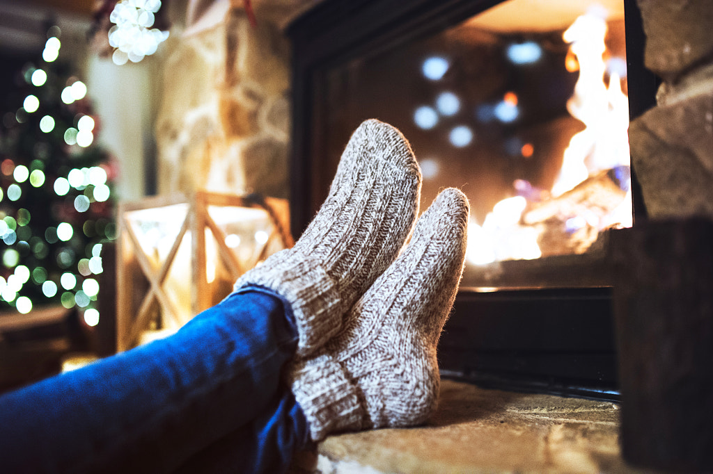 Feet of unrecognizable woman in front of the fireplace. by Jozef Polc on 500px.com