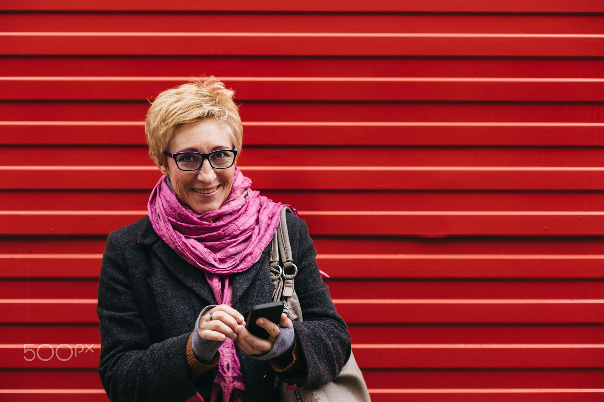 Smiling adult woman with smartphone