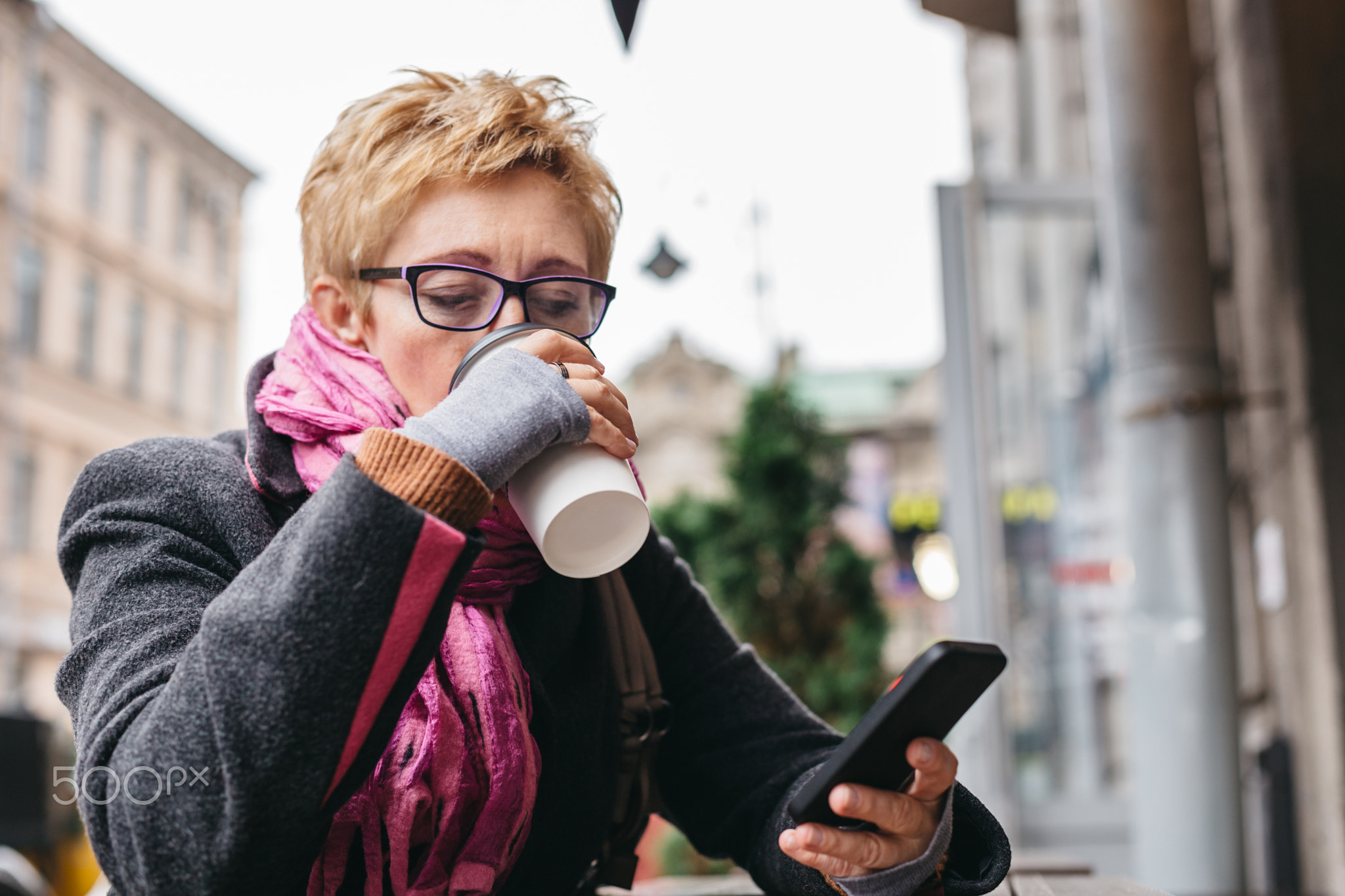 Woman drinking coffee with smartphone