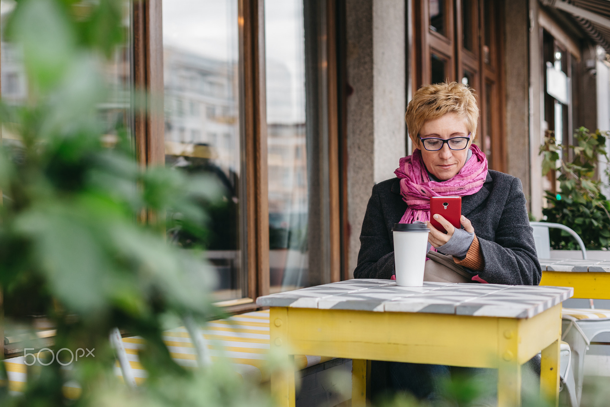 Woman with drink and smartphone