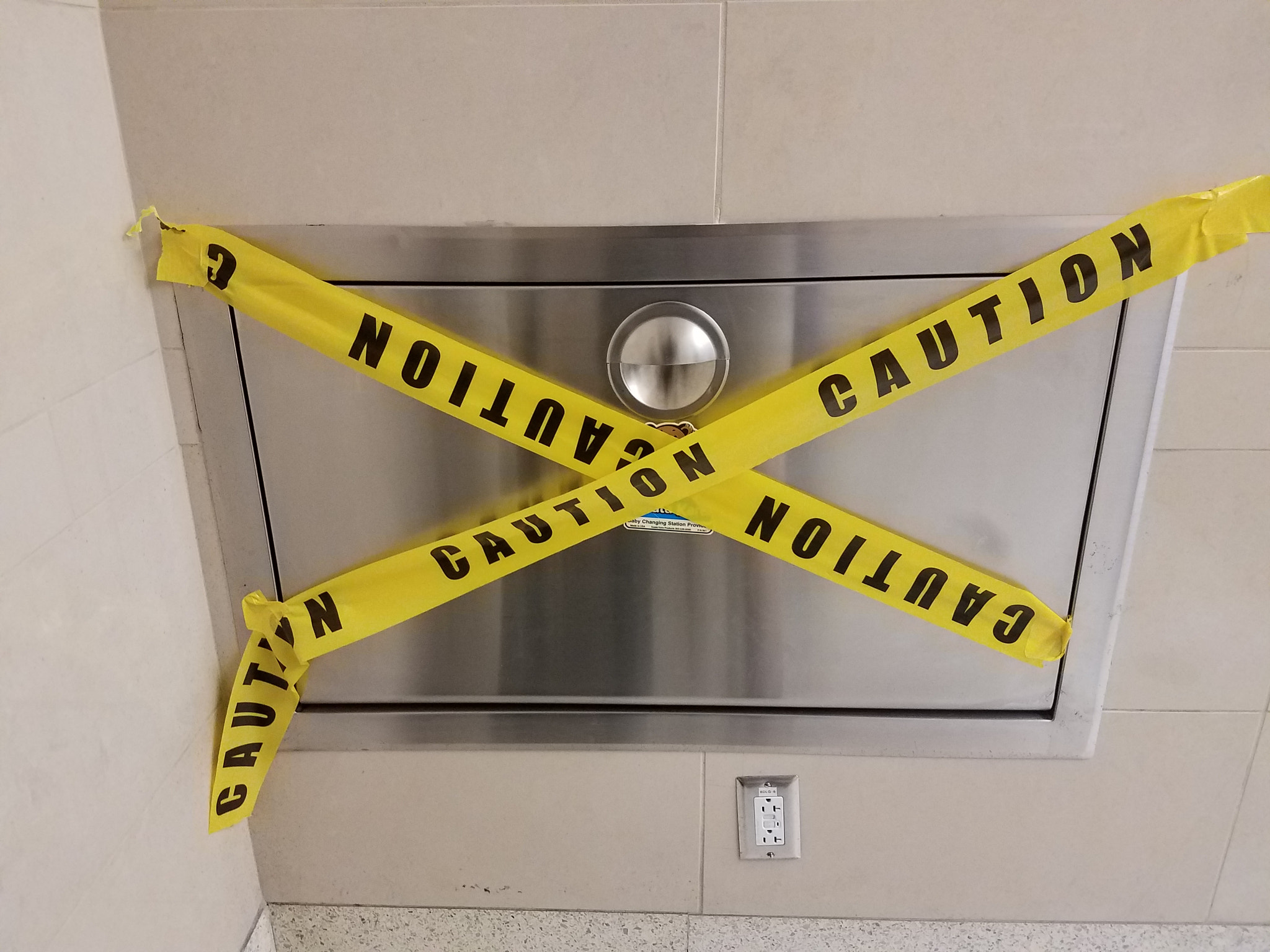 a baby changing table with yellow caution tape on it