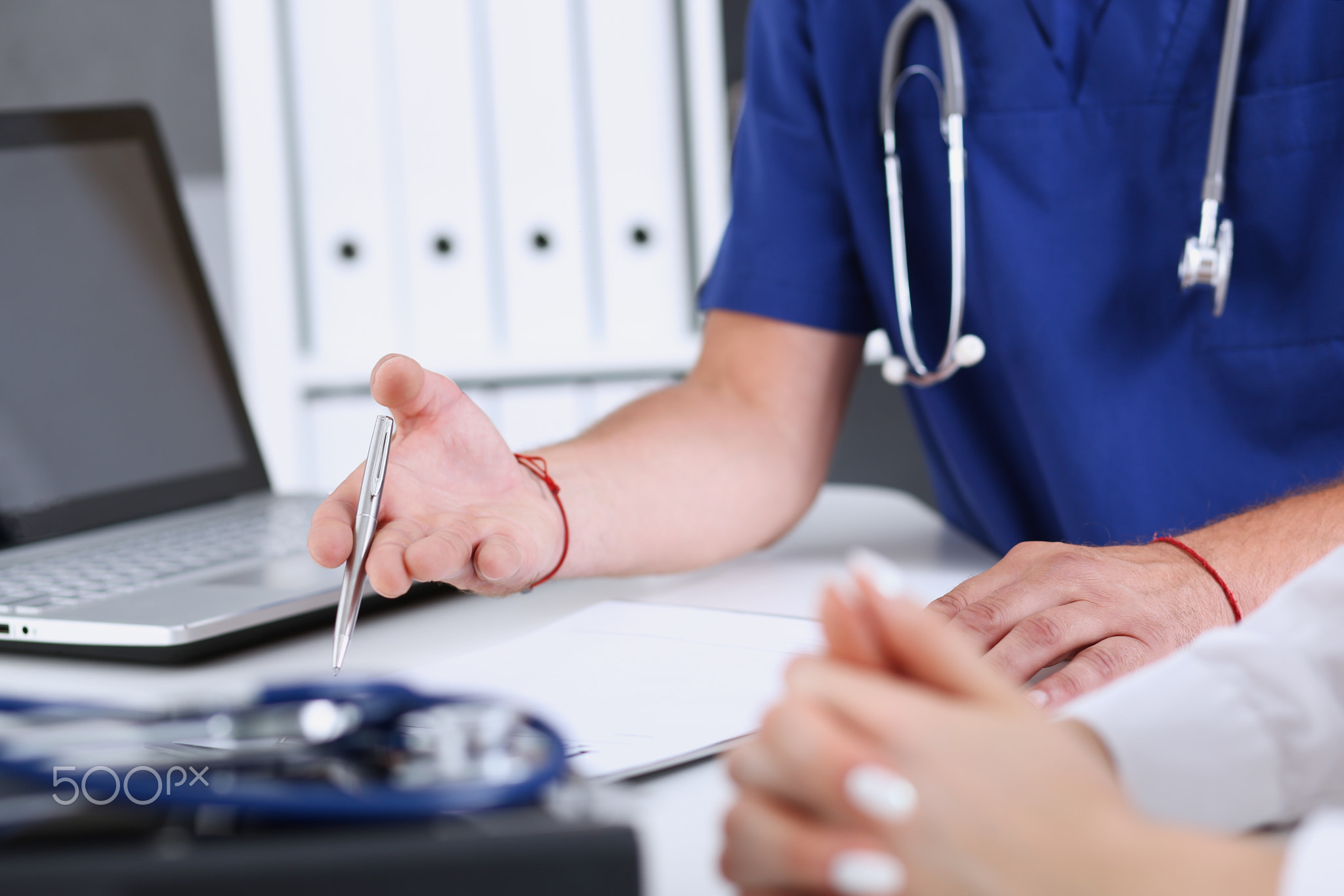 Male doctor arm hold silver pen filling patient complaints