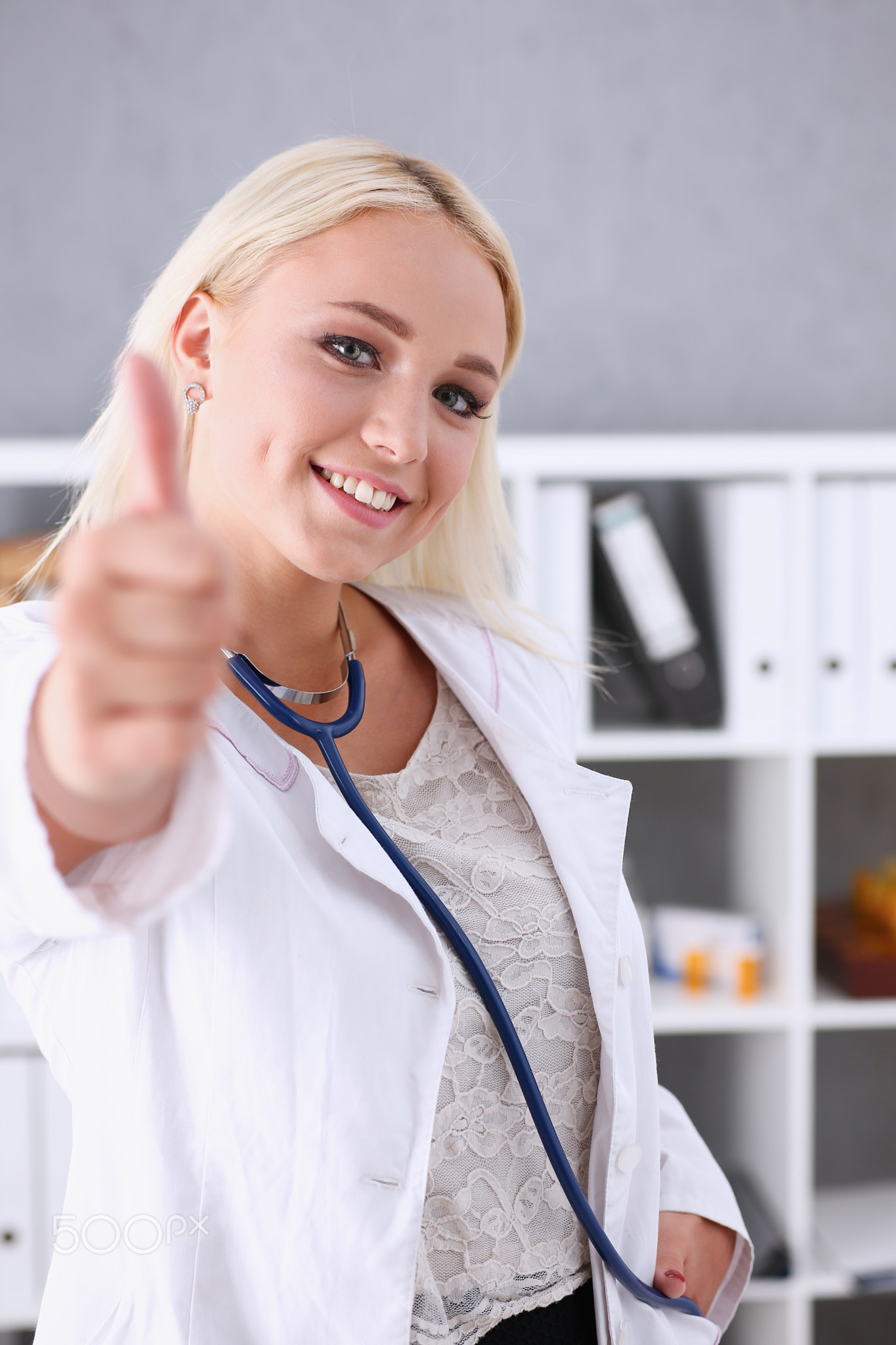Beautiful smiling female doctor showing OK or confirm sign