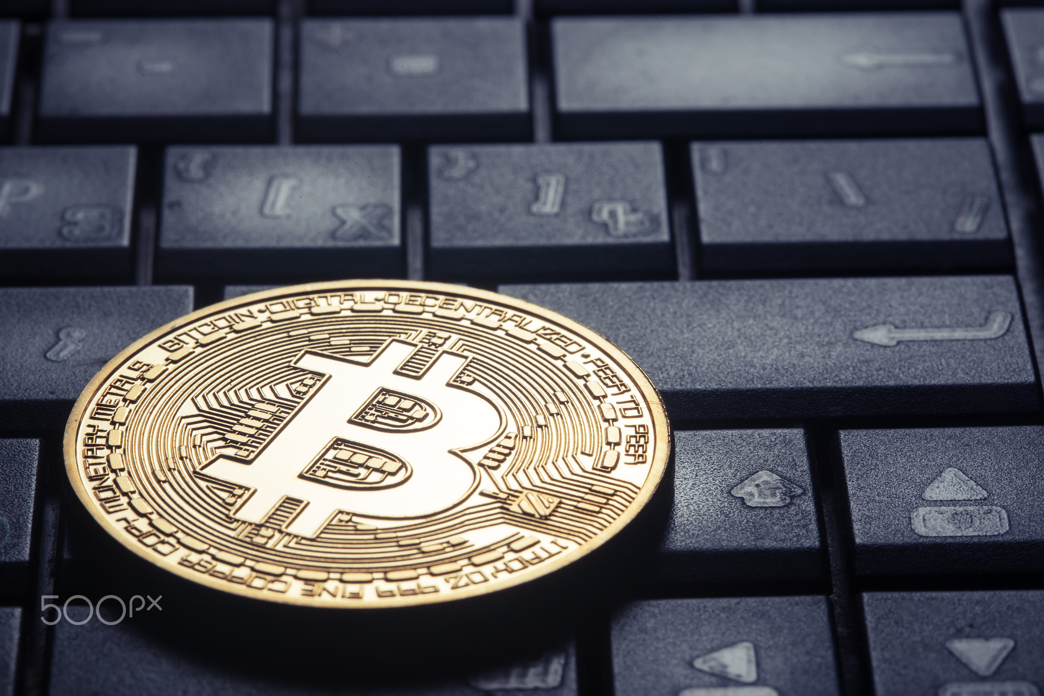 Golden bitcoin on the computer keyboard
