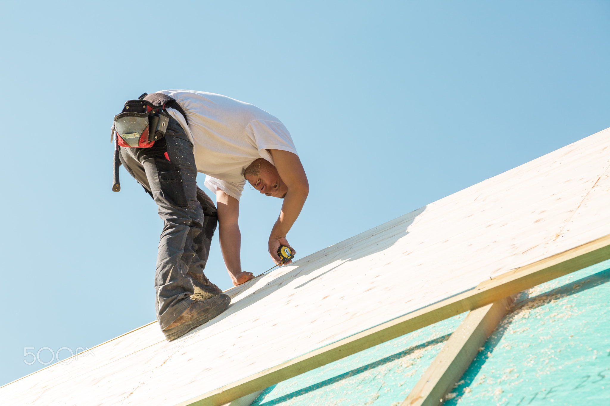 Builder at work with wooden roof construction.