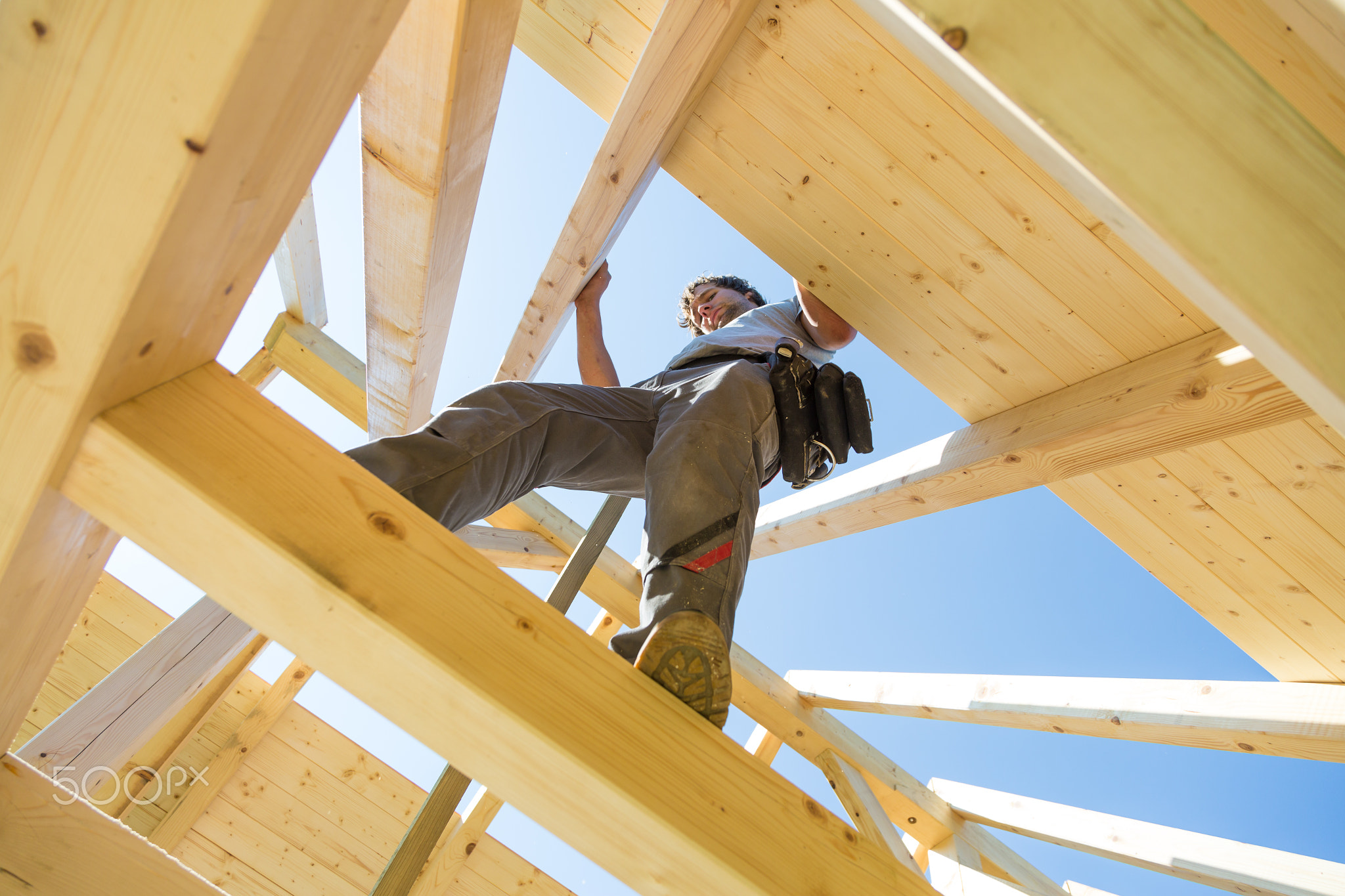 Builders at work with wooden roof construction.