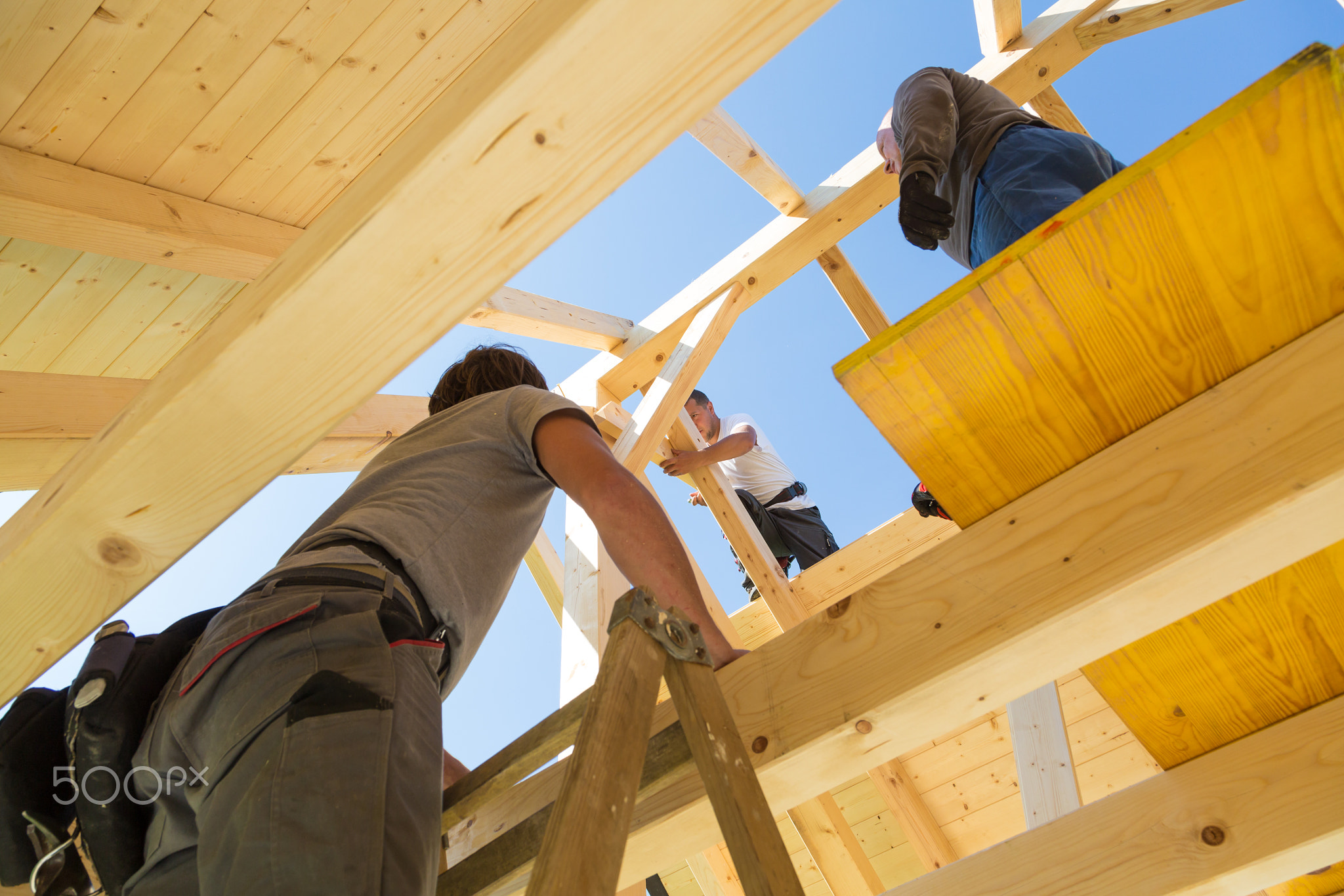 Builders at work with wooden roof construction.