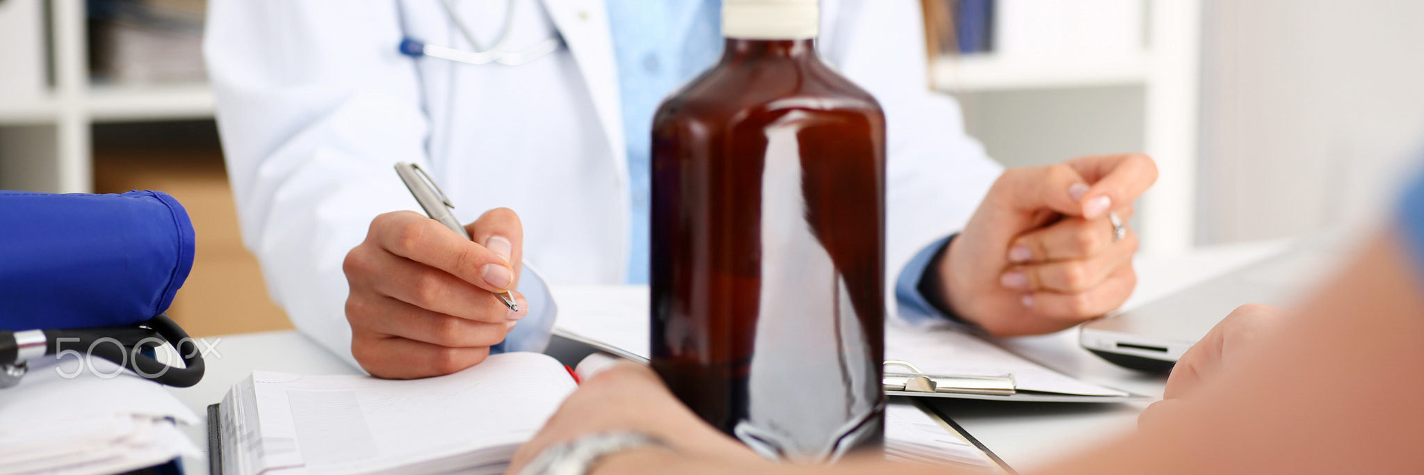 Alcoholic hold in arm empty bottle at doctor reception