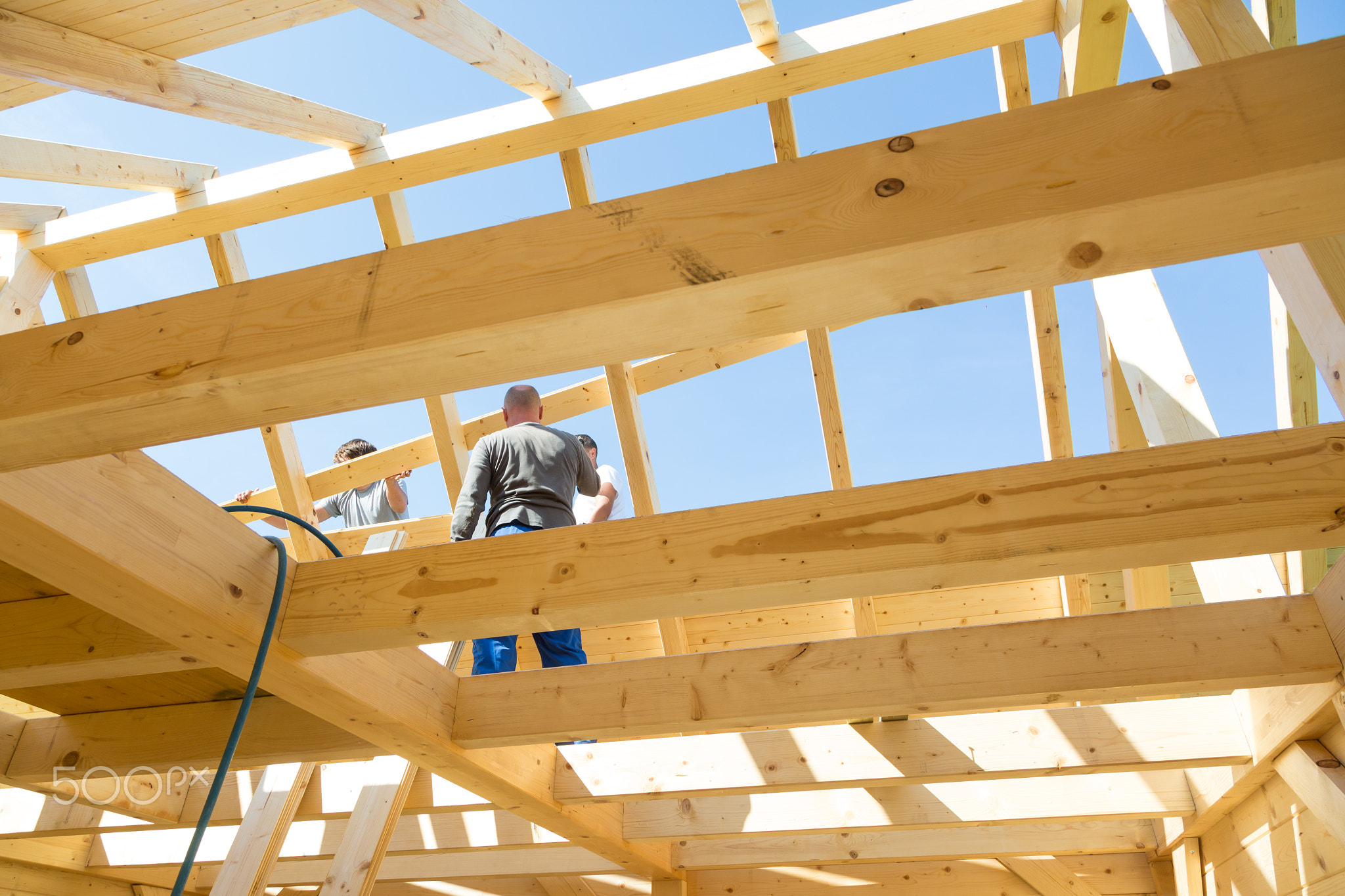 Builders at work with wooden roof construction.