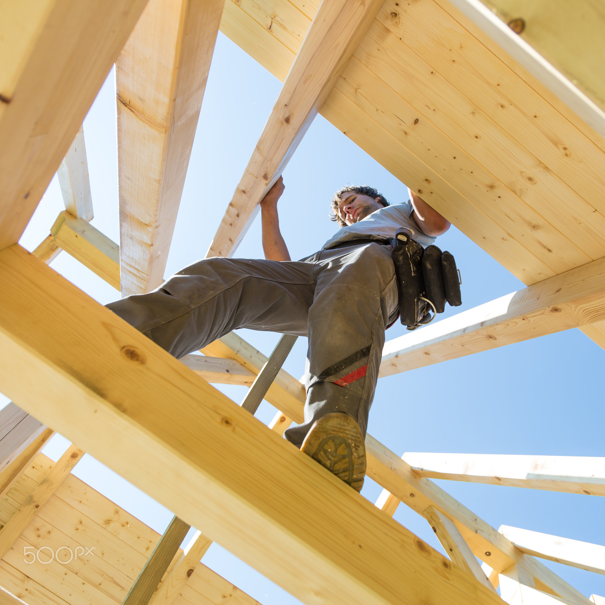 Builders at work with wooden roof construction.