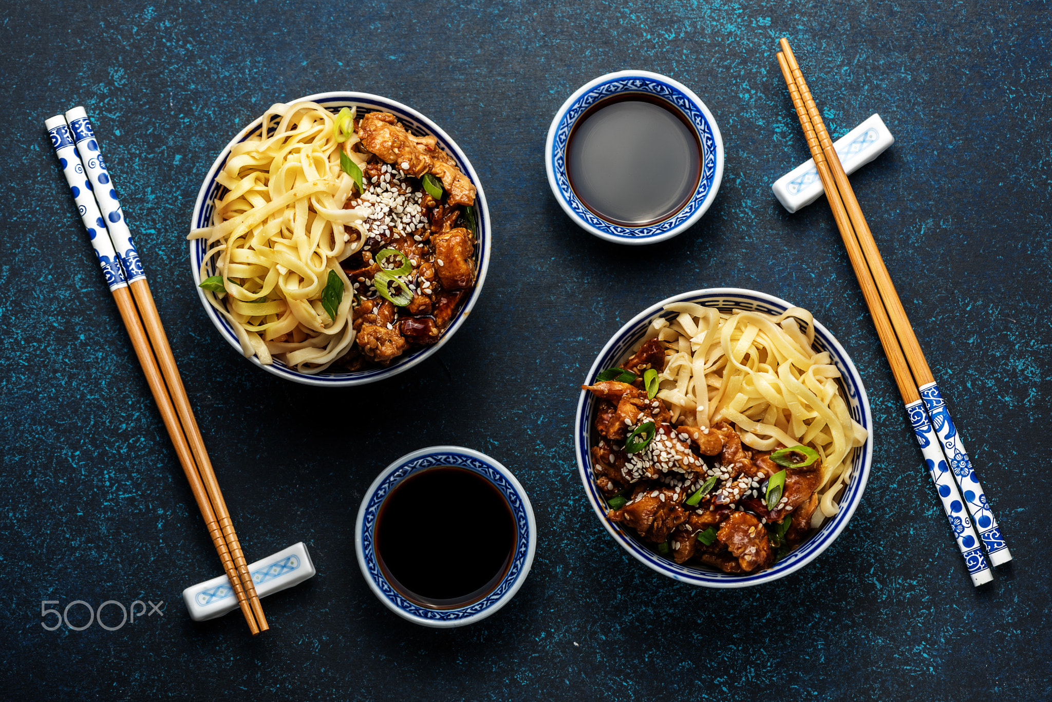 Chicken teriyaki on dark background with balsamic sauce and sesame seeds. Asian food. Noodles,...