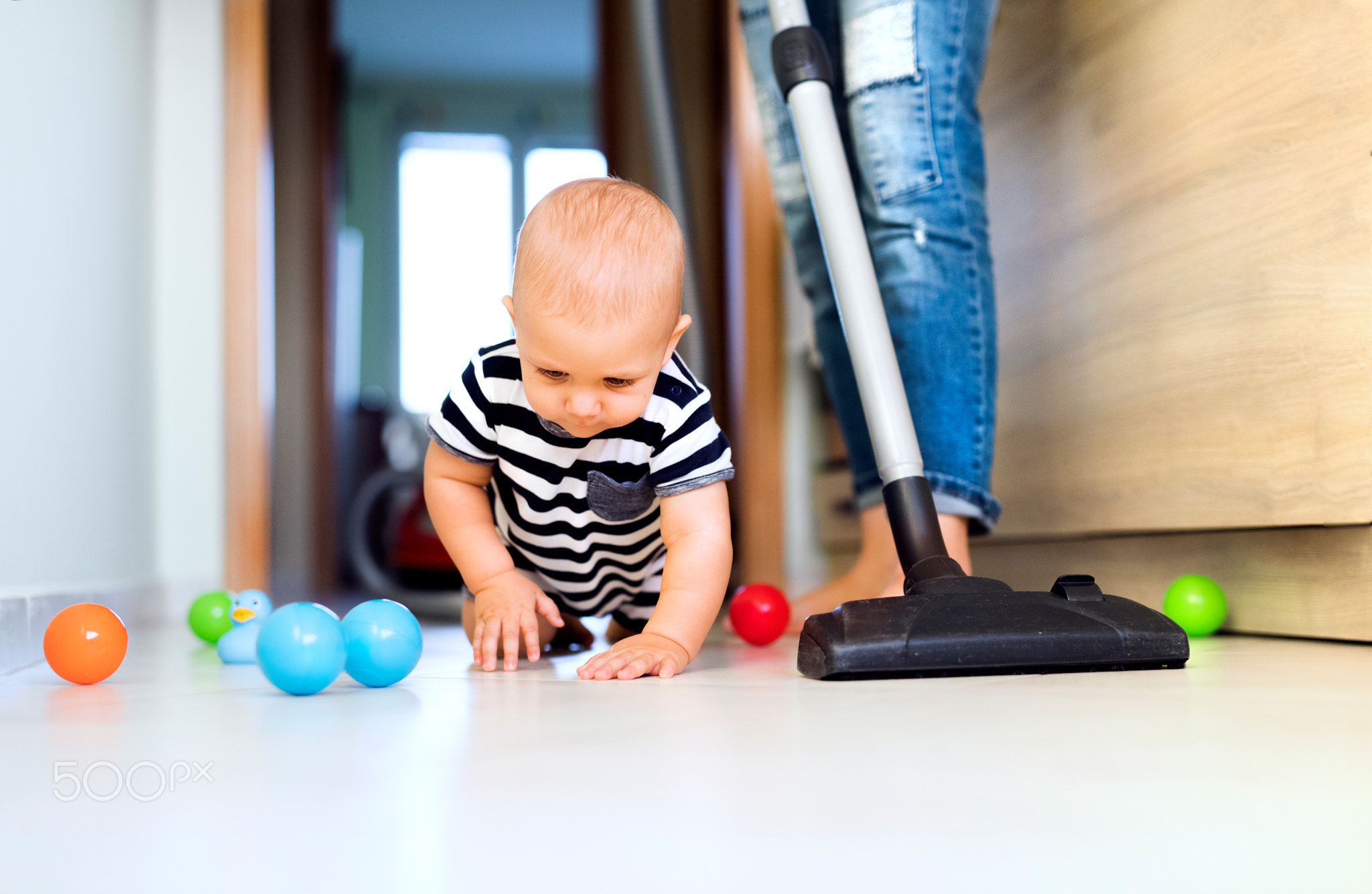 Young mother with a baby boy doing housework.