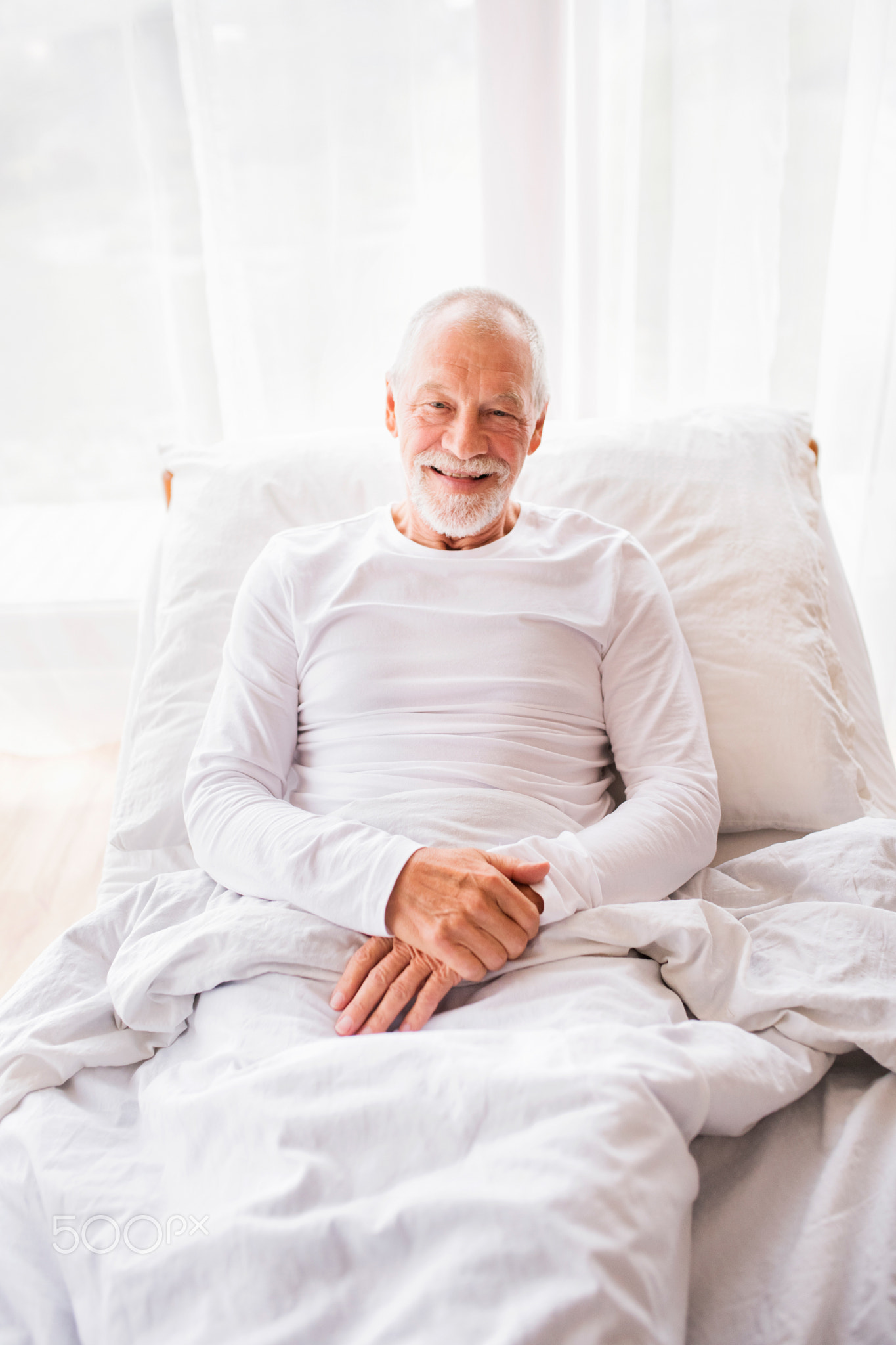 Senior man lying in bed at home.
