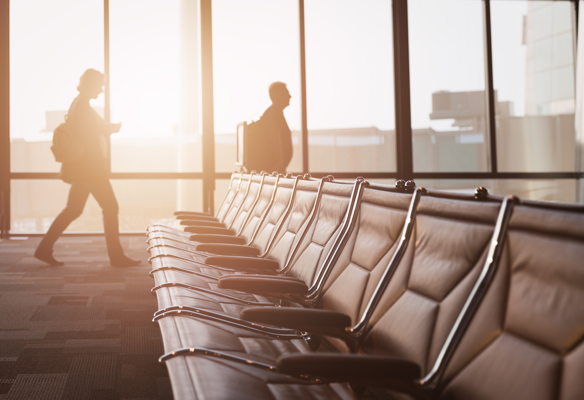 Empty seat with walking passengers to flight