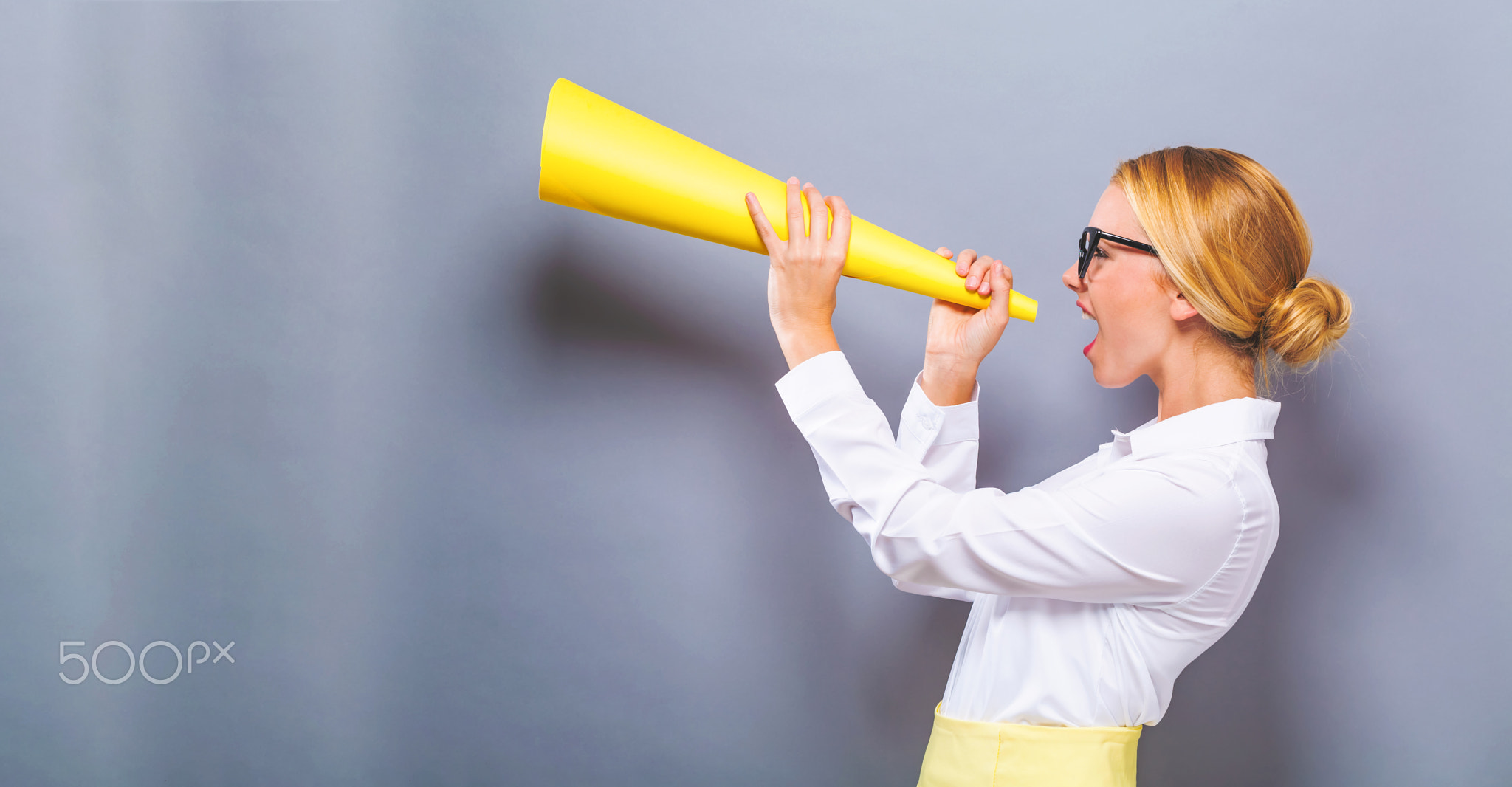 Young woman holding a paper megaphone