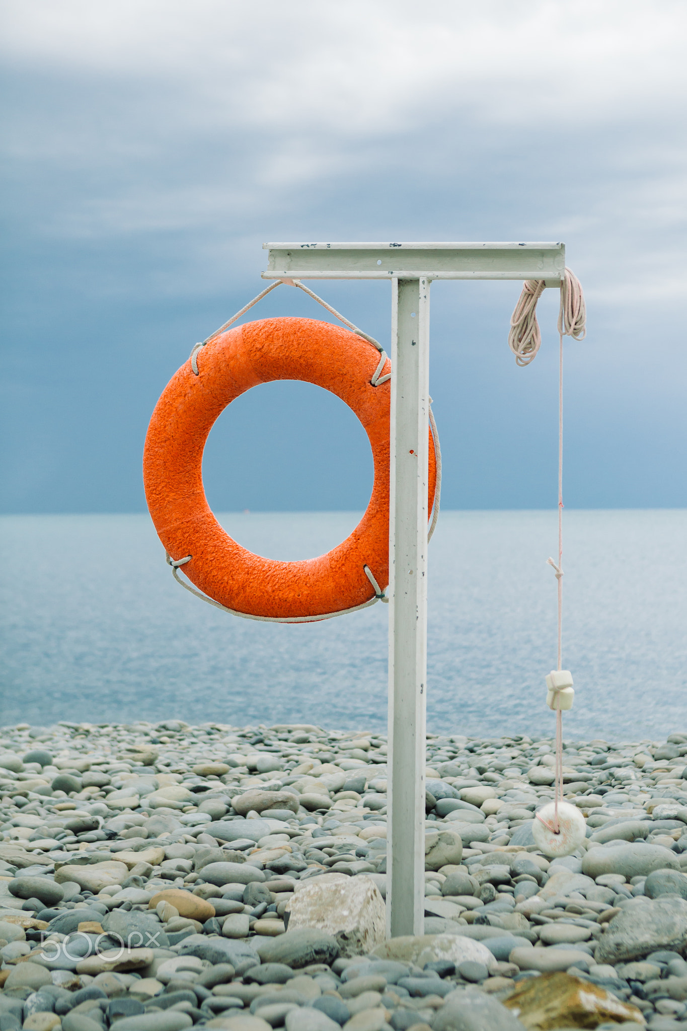 orange lifebuoy on the sea coast