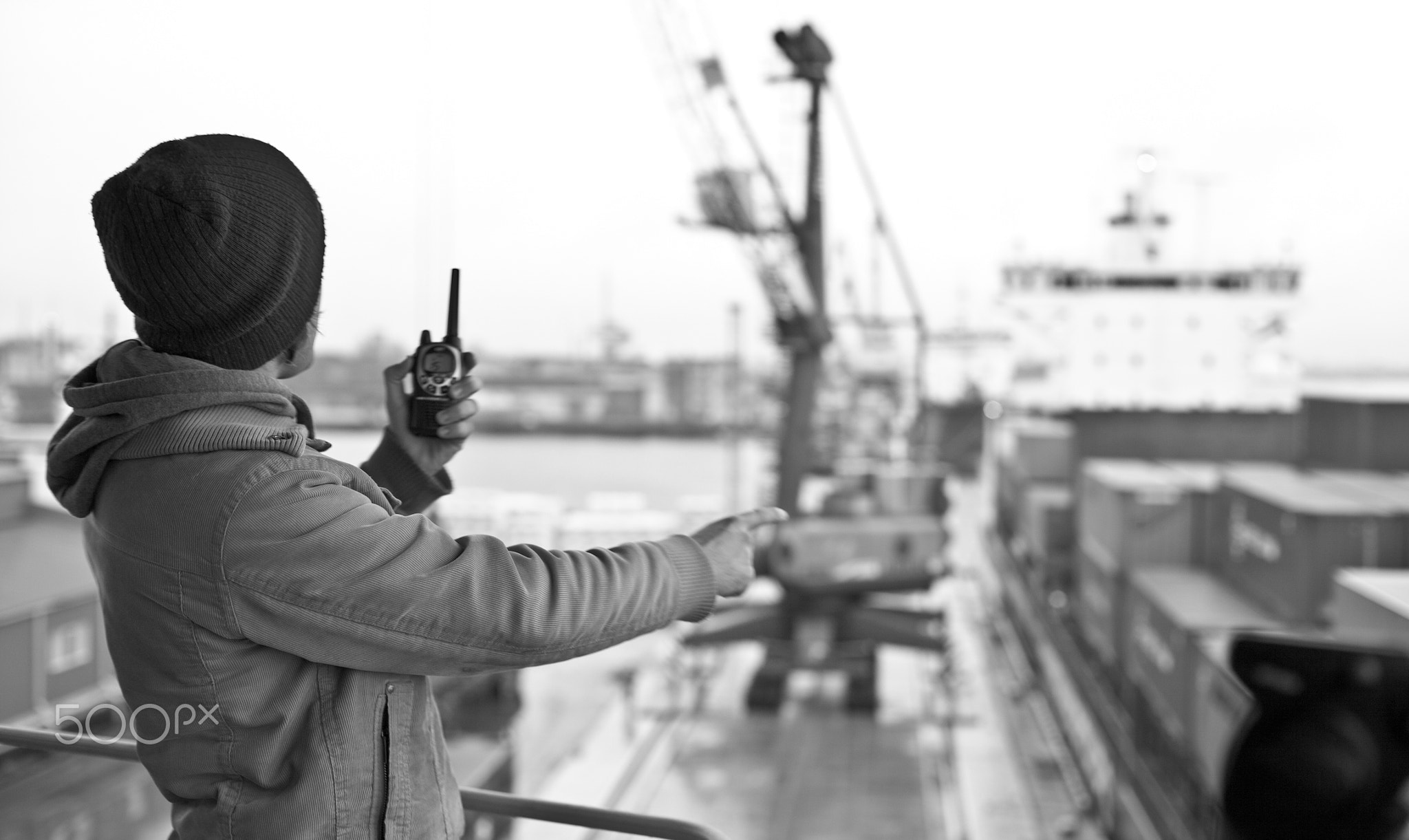 Cargo pier and worker containers and cranes man with walkie-talkie port