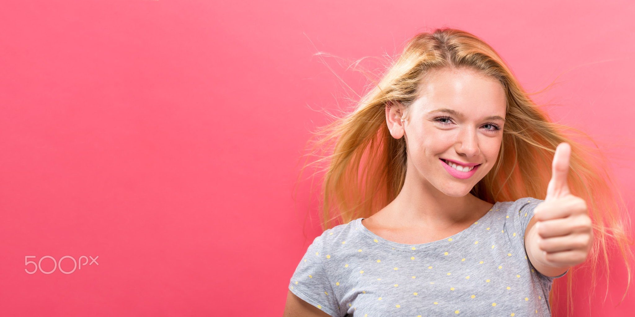 Happy young woman giving thumbs