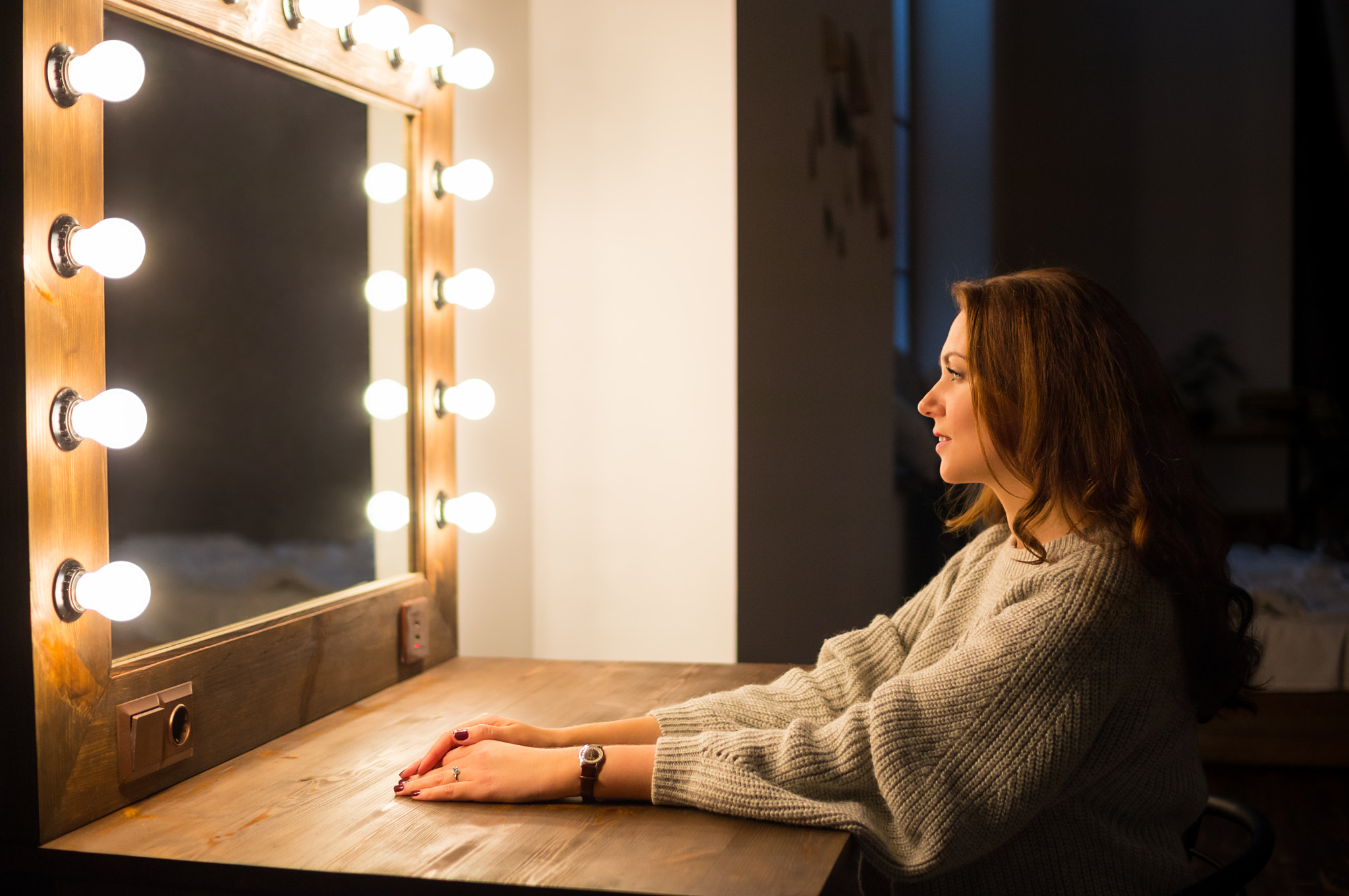 Woman sitting in front of a make-up mirror