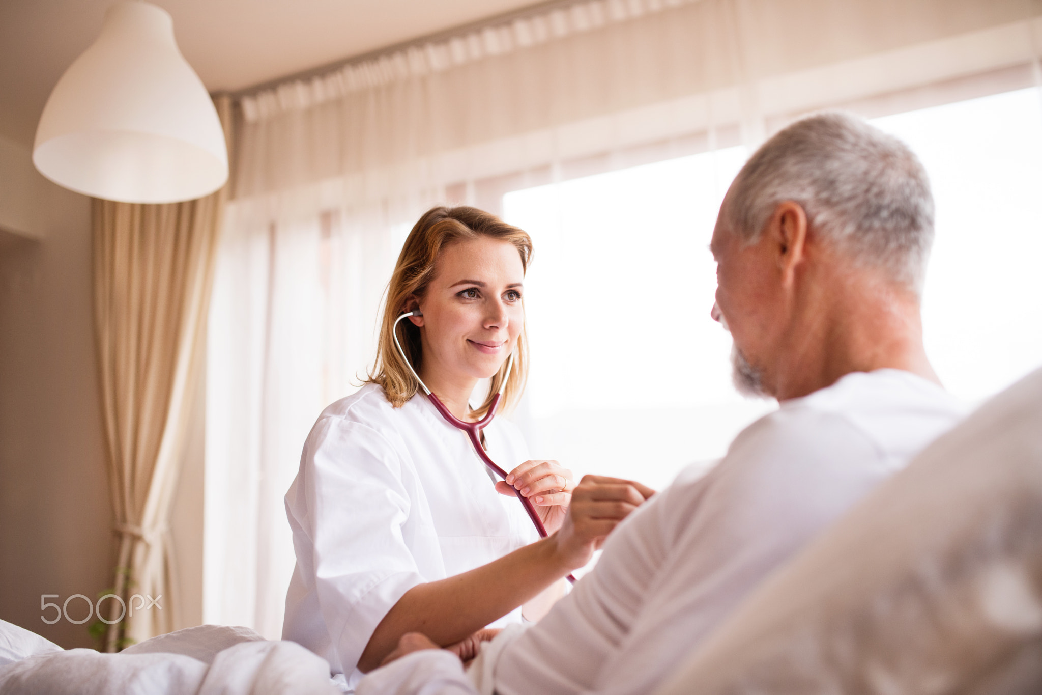 Health visitor and a senior man during home visit.