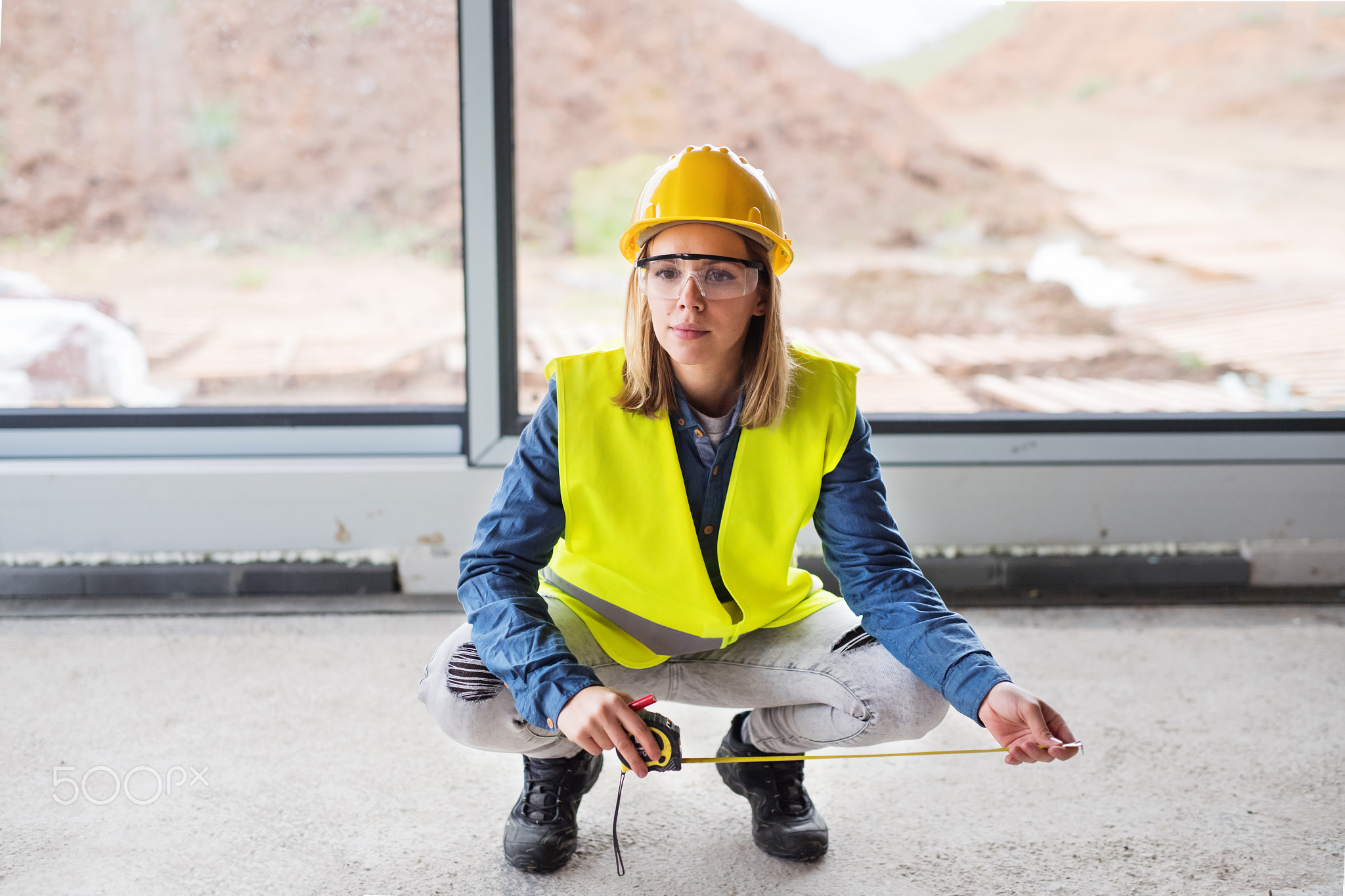 Young woman worker on the building site.