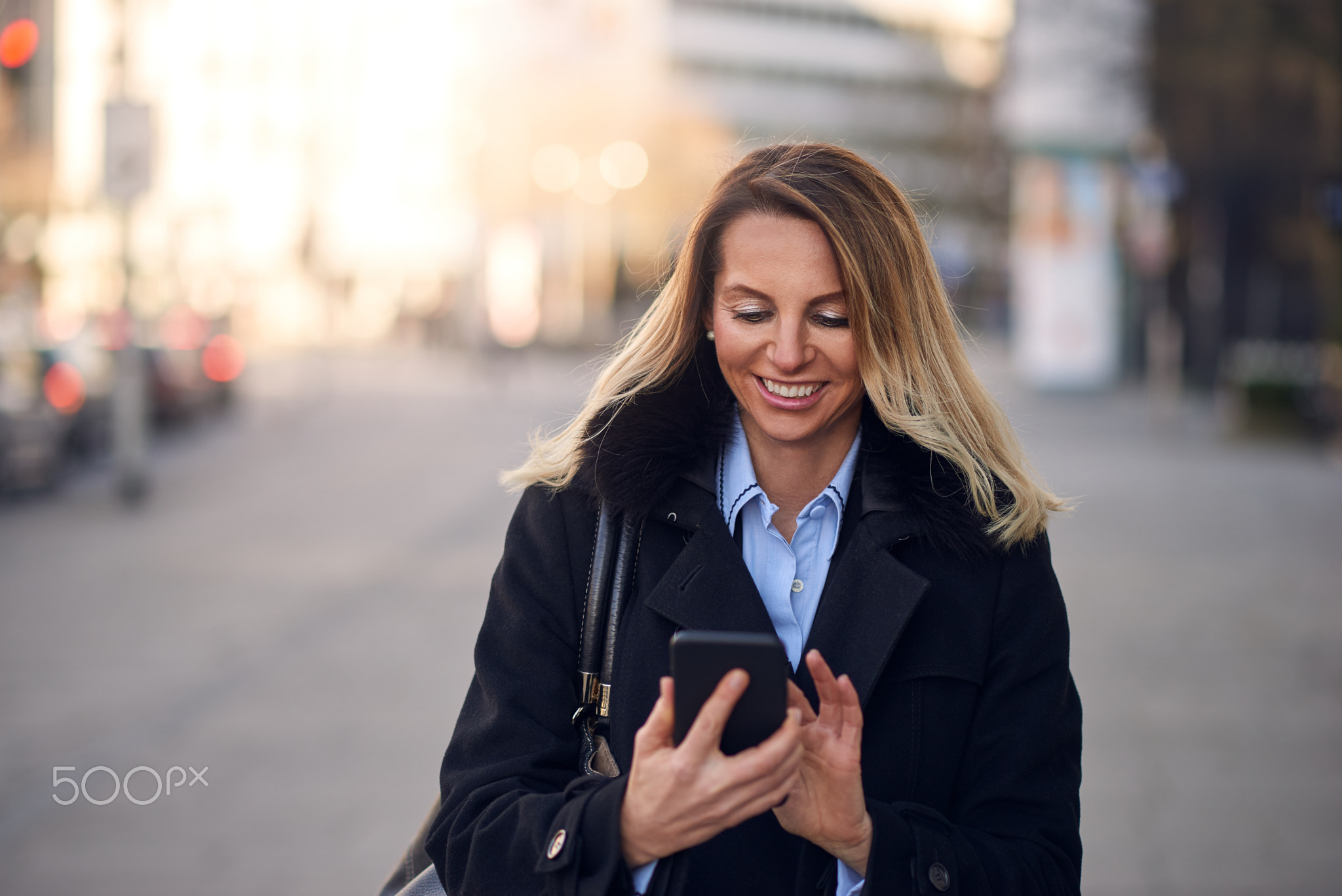 Fashionable Woman Busy with Phone at City Street